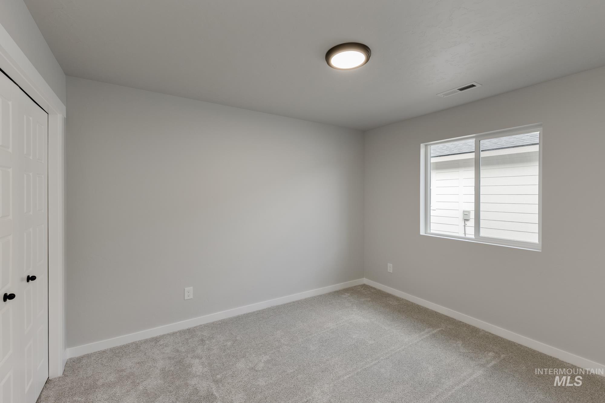 Unfurnished bedroom featuring a closet and light colored carpet