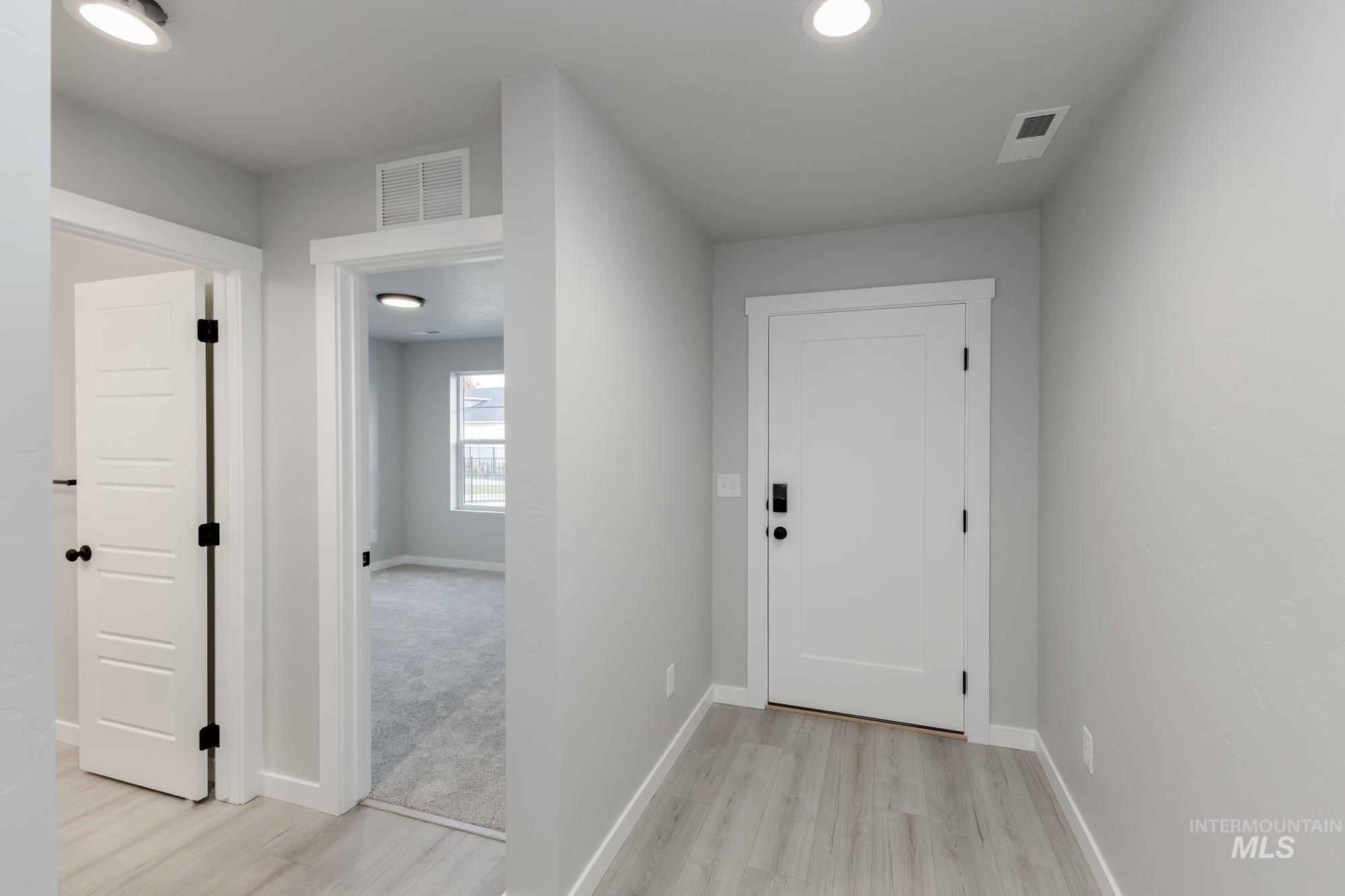 Hall featuring light wood-type flooring and recessed lighting