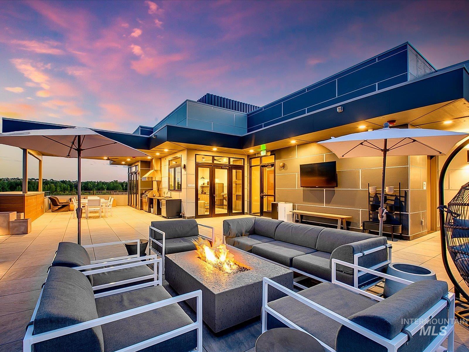 Patio terrace at dusk with an outdoor living space with a fire pit, a patio, and outdoor dining space