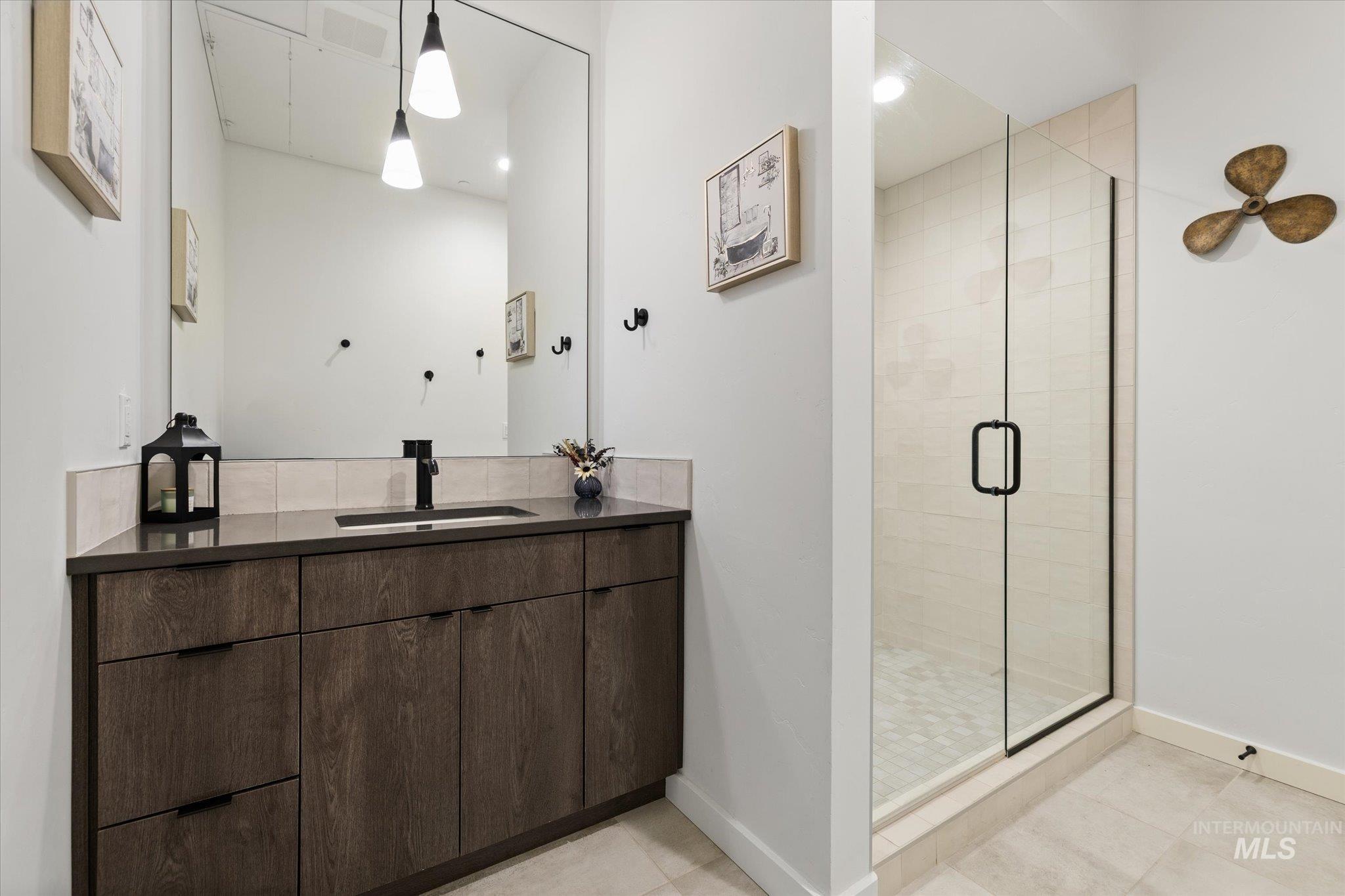 Bathroom with vanity, a stall shower, and light tile patterned floors