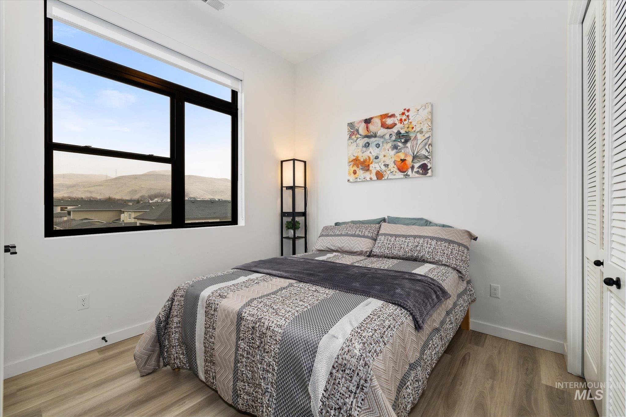 Bedroom featuring wood finished floors, a mountain view, and a closet