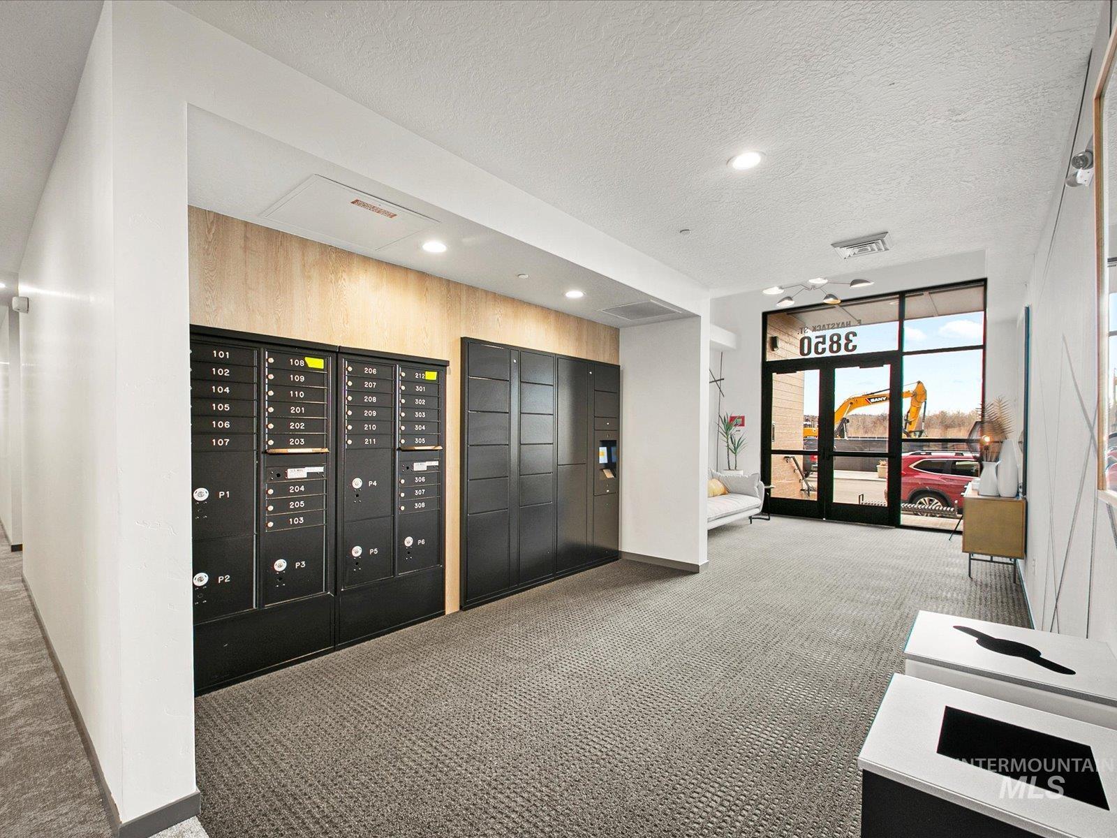 Community lobby featuring a textured ceiling, recessed lighting, and a wall of windows