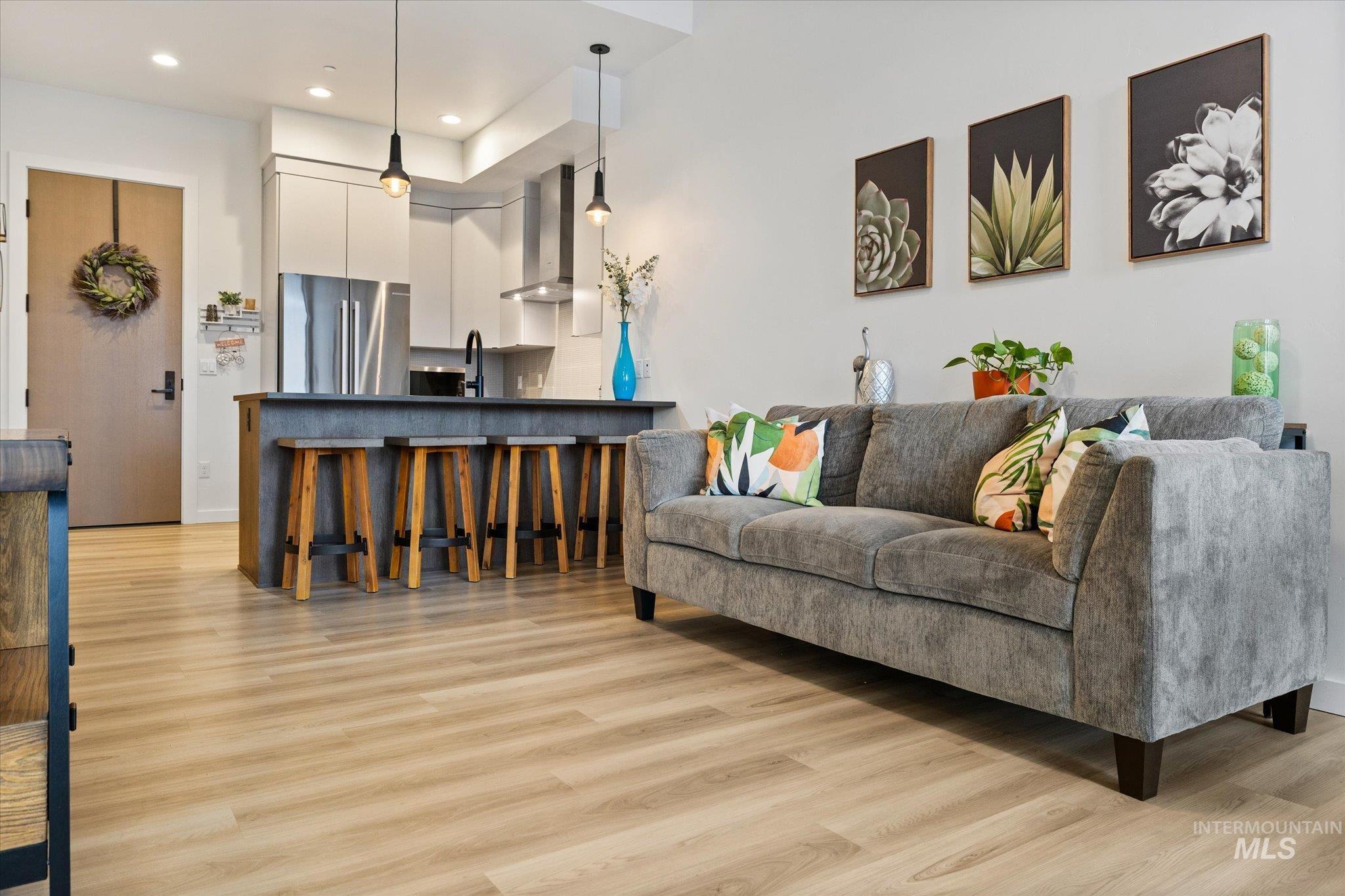 Living area with light wood finished floors and recessed lighting