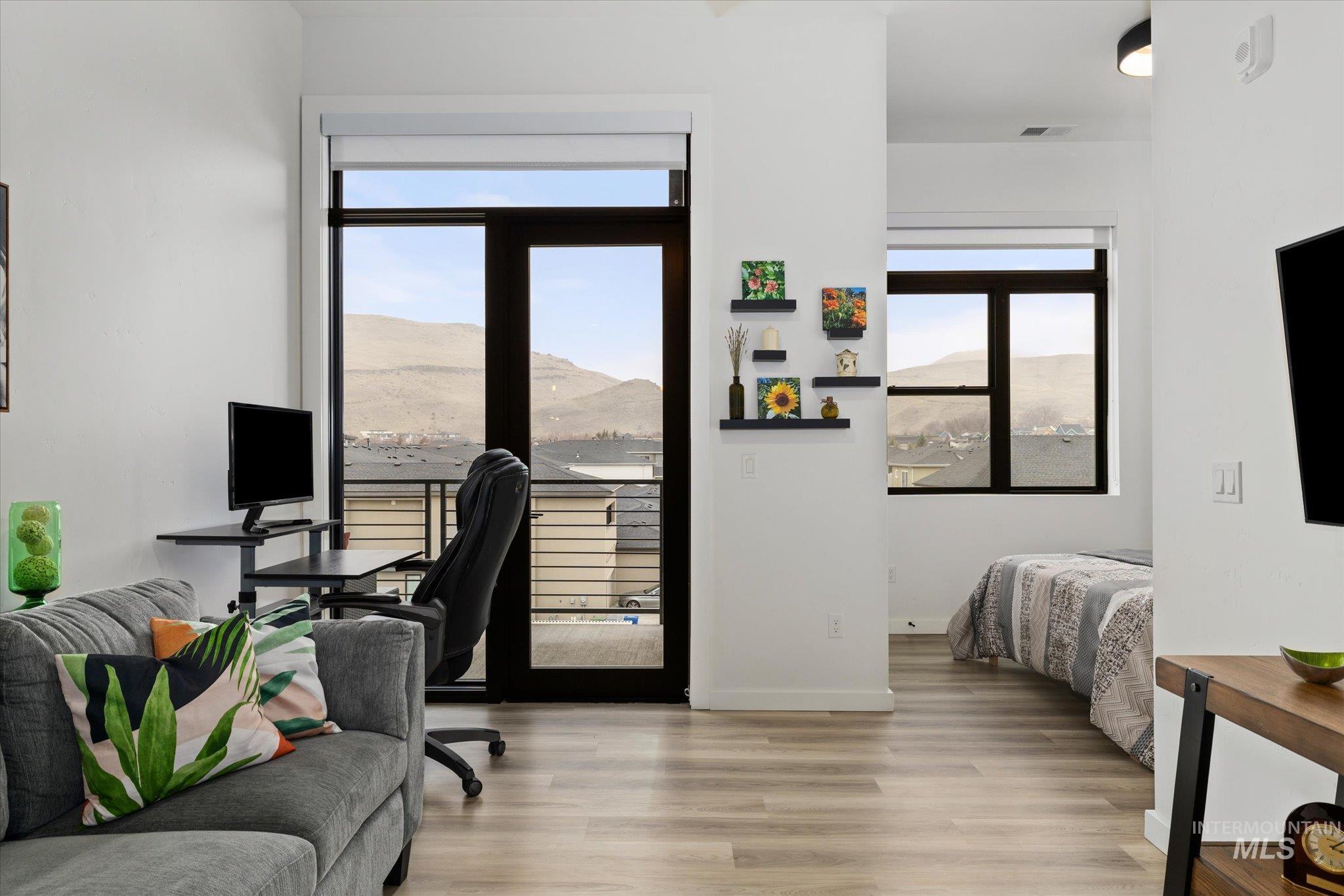 Bedroom with a desk, access to exterior, and light wood-style flooring