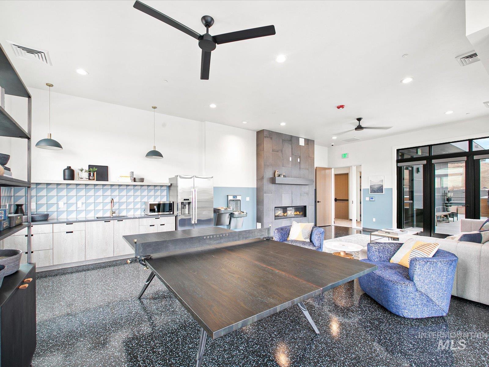 Living area with granite tiled floors, recessed lighting, a tiled fireplace, and a ceiling fan