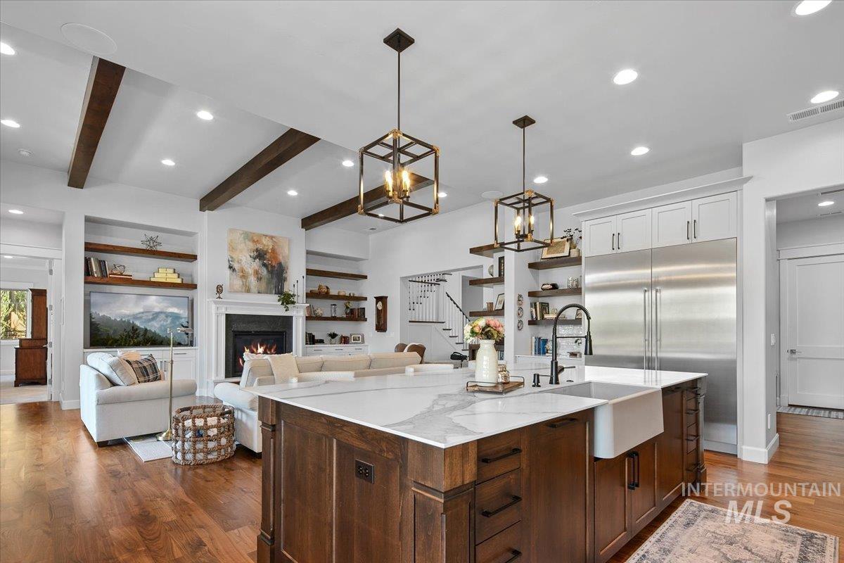 Kitchen with recessed lighting, dark wood-style flooring, stainless steel built in refrigerator, beam ceiling, and open shelves