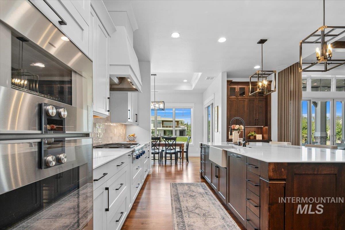Kitchen featuring a chandelier, stainless steel appliances, dark wood finished floors, white cabinets, and recessed lighting