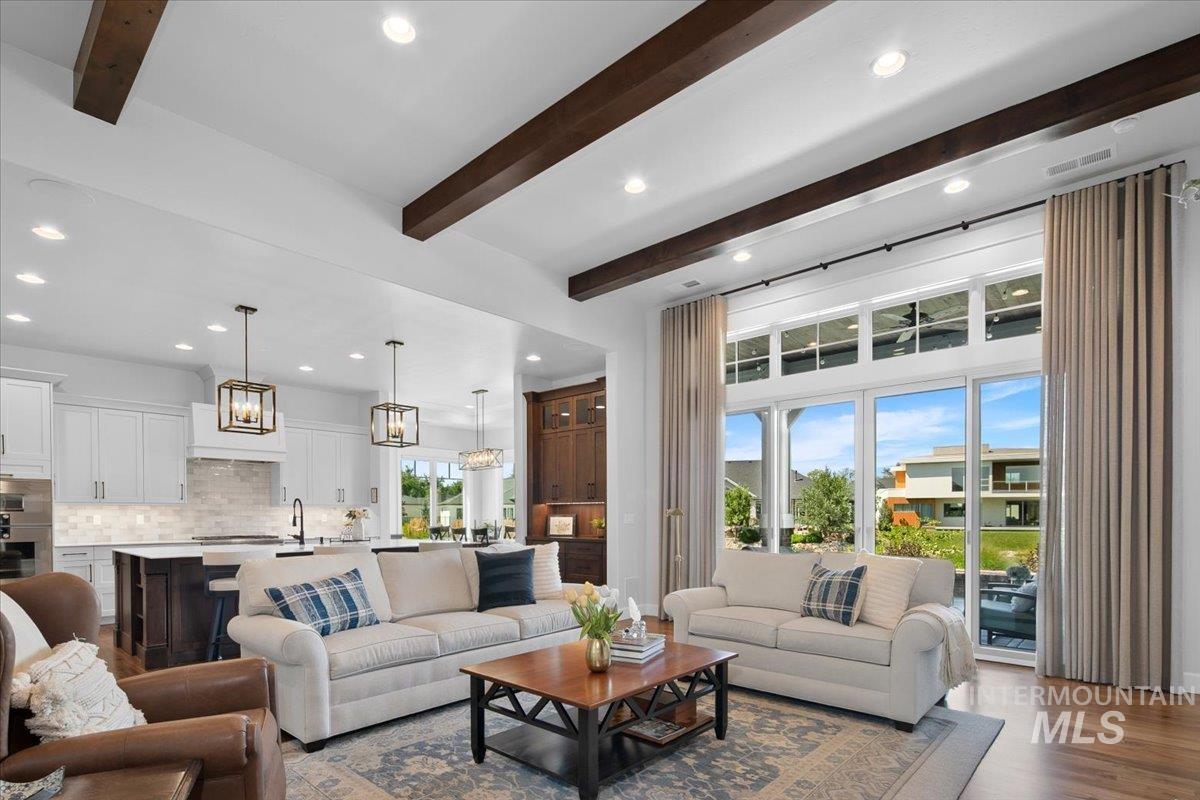 Living area with beam ceiling, recessed lighting, and wood finished floors