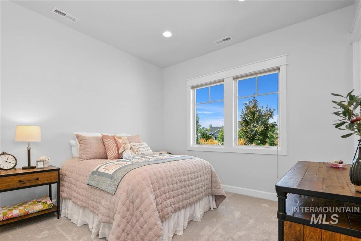 Bedroom with light carpet and recessed lighting