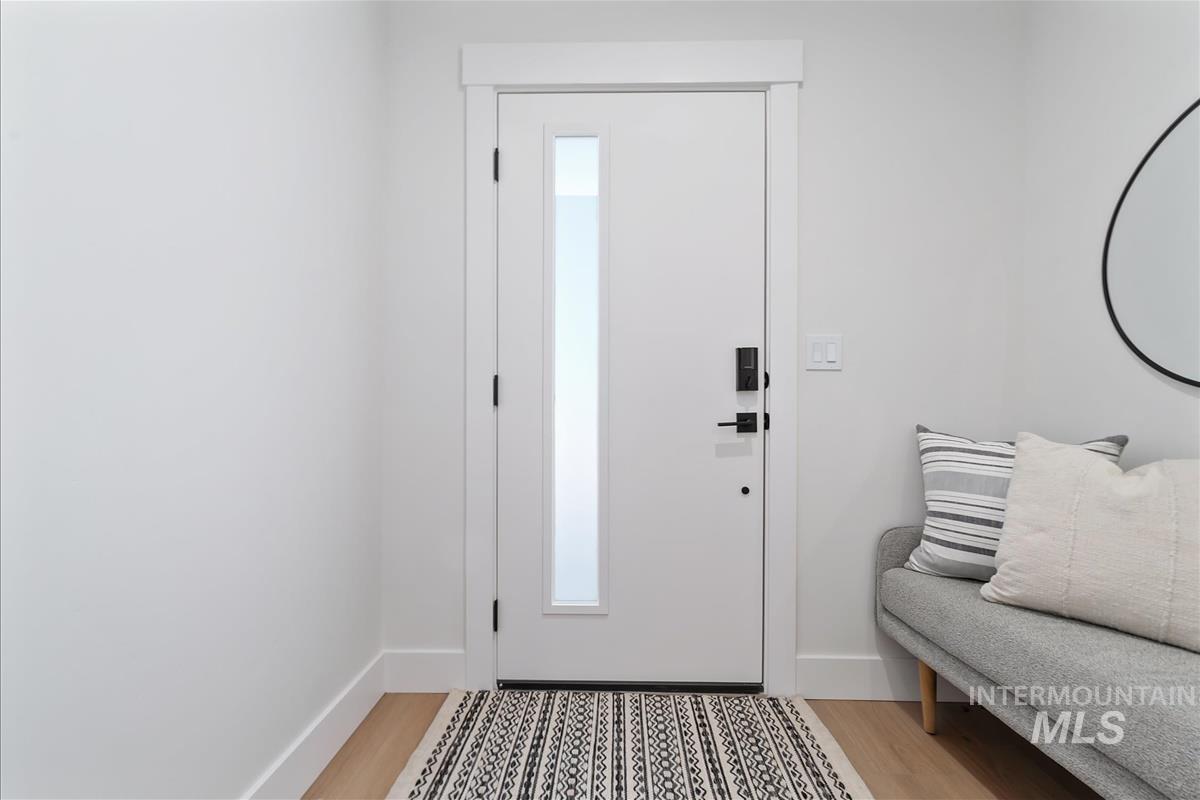Entrance foyer with light wood-style floors and baseboards