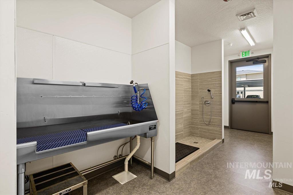 Misc room featuring pet washing station and a textured ceiling