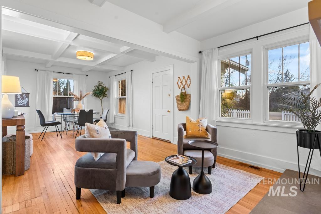 Sitting room with beamed ceiling, light wood-type flooring, and coffered ceiling