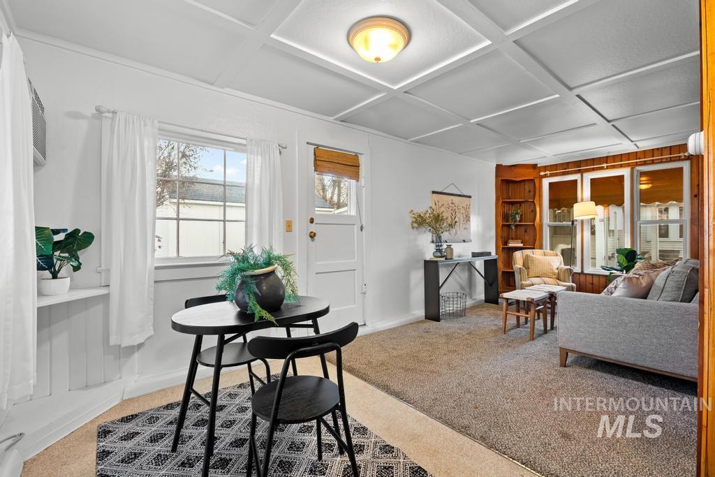 Dining area featuring coffered ceiling, light colored carpet, and built in features