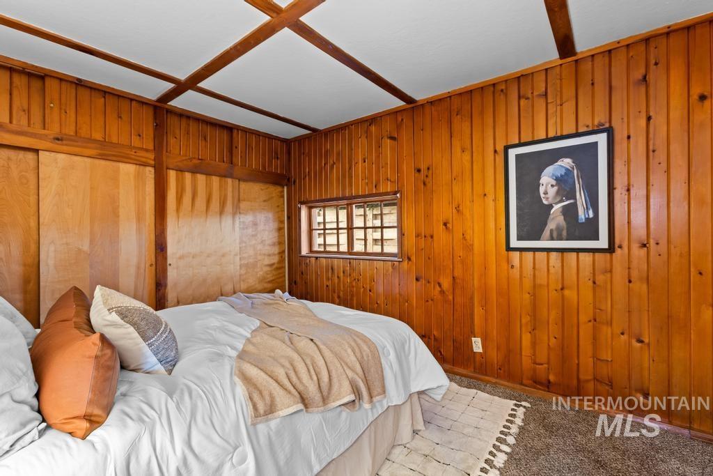 Bedroom featuring wood walls and carpet flooring