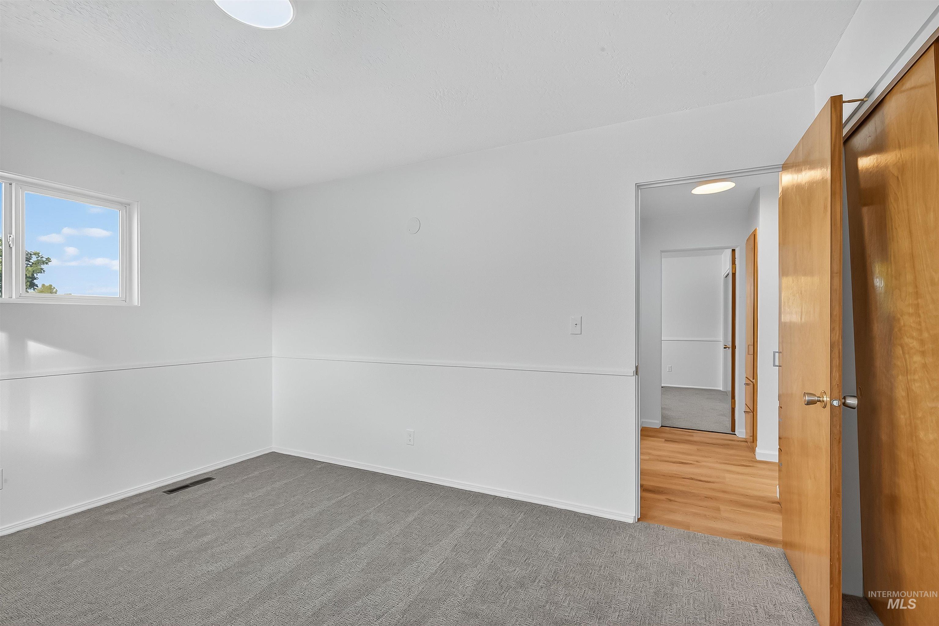 Unfurnished room with carpet flooring and baseboards