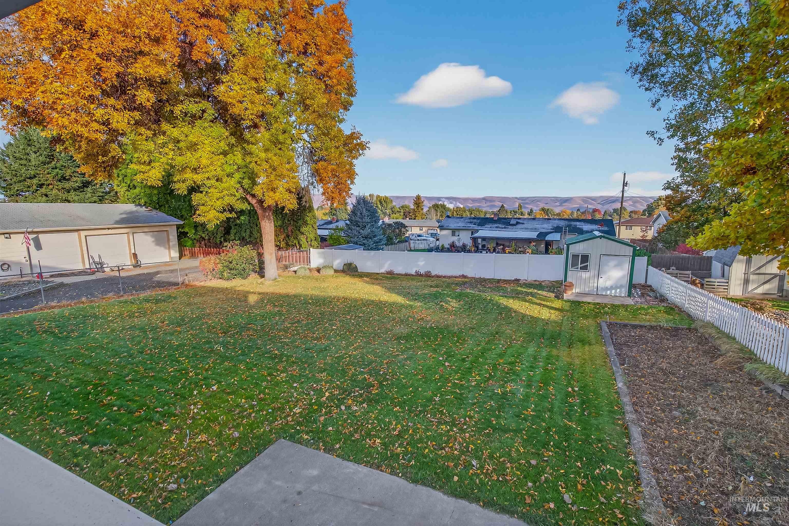 Fenced backyard featuring a storage shed and a mountain view