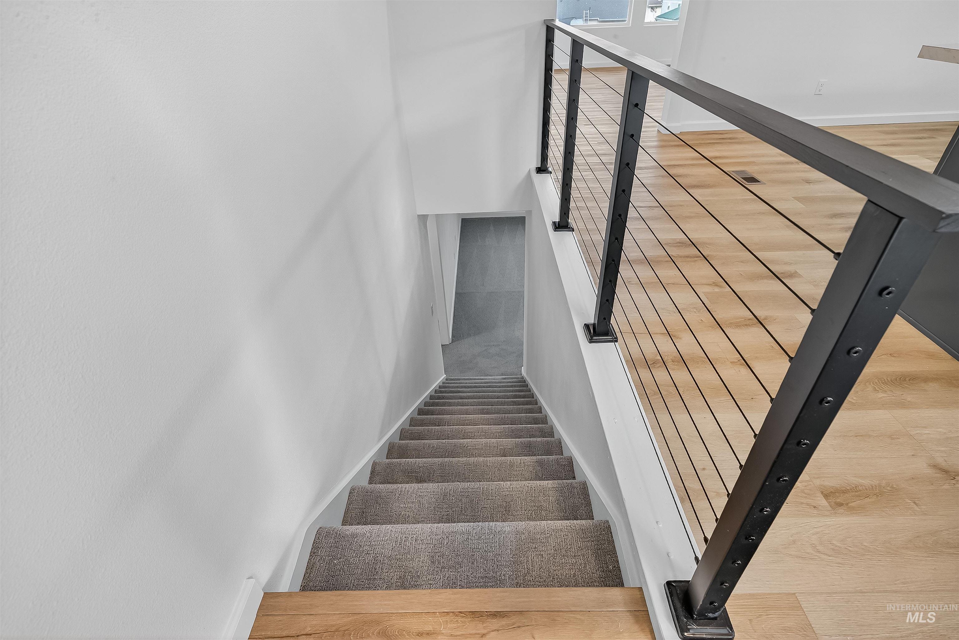 Stairs featuring wood finished floors and baseboards