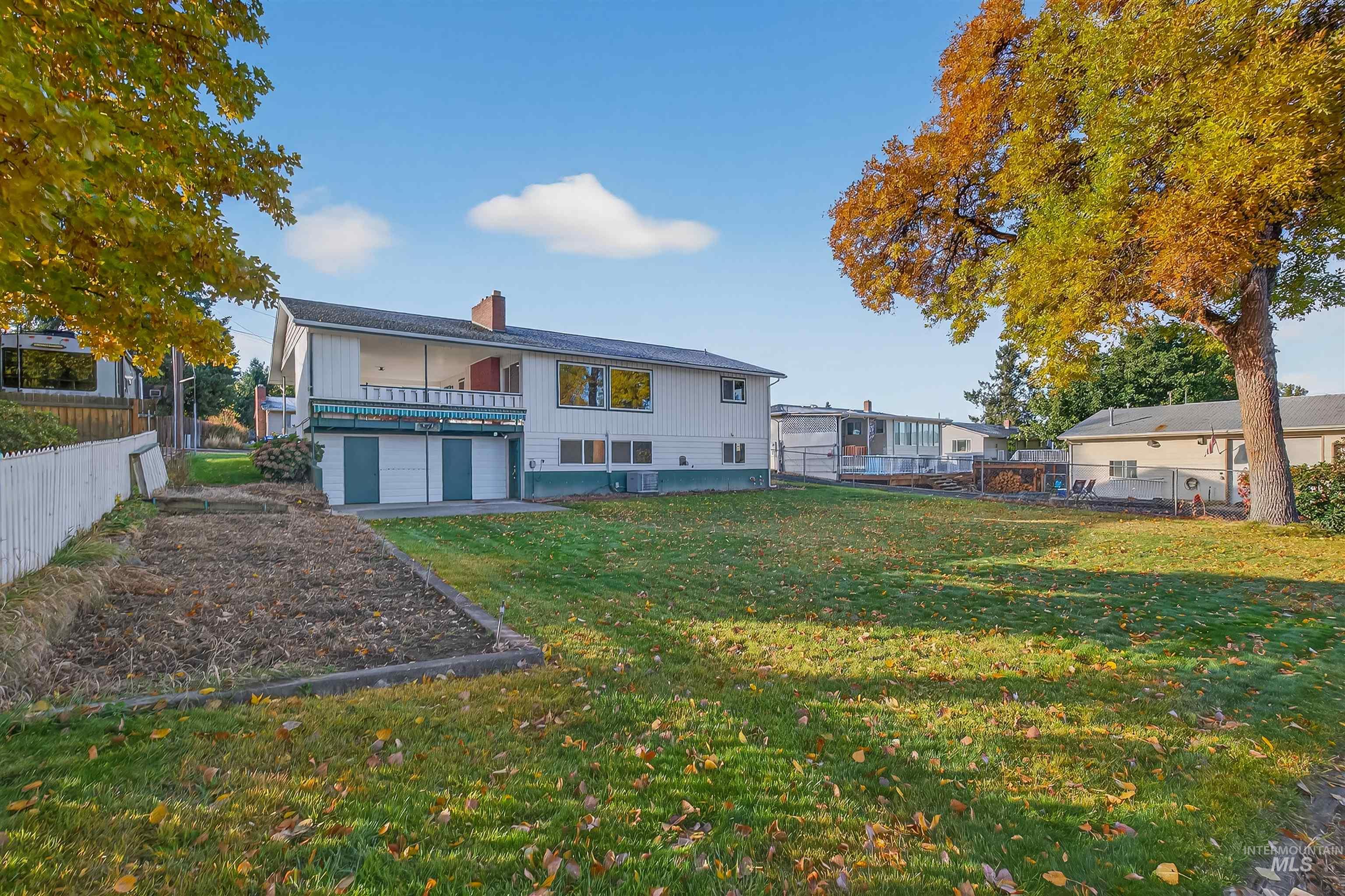 Rear view of property featuring a chimney and a patio area