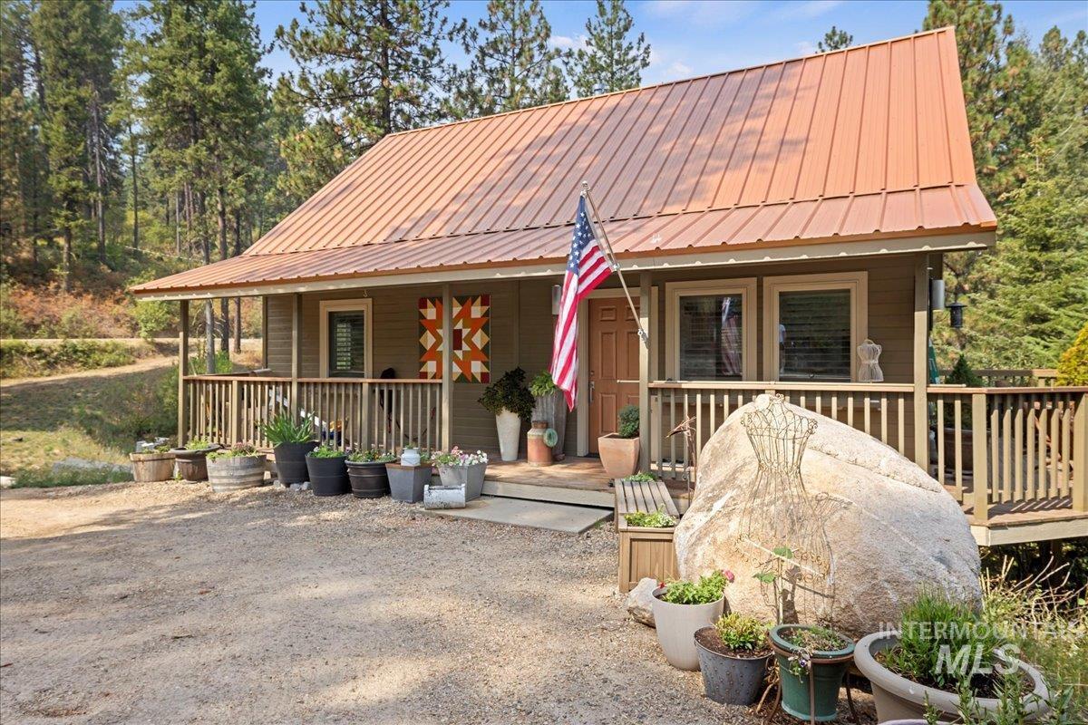 Rustic home featuring a porch and a metal roof