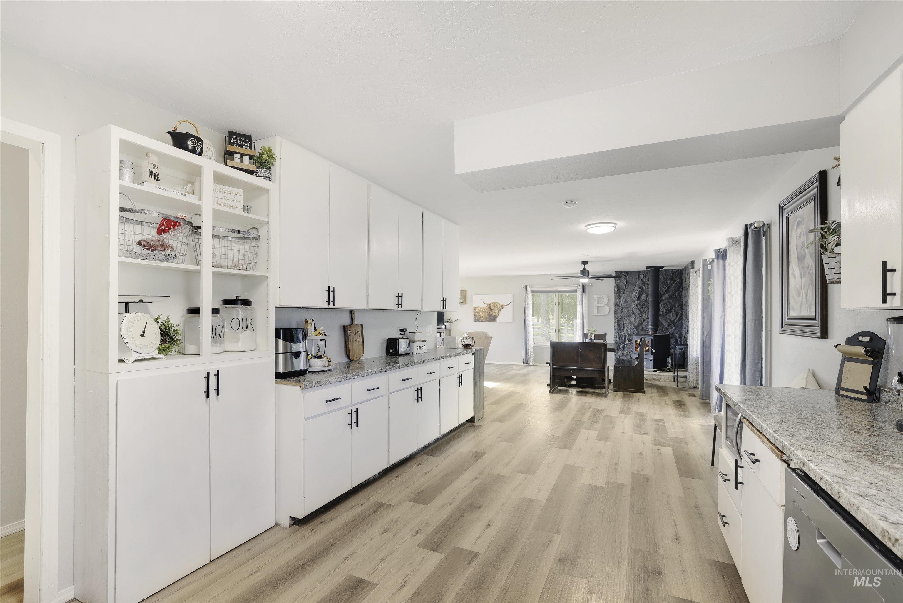 Kitchen with open shelves, light wood finished floors, and white cabinetry