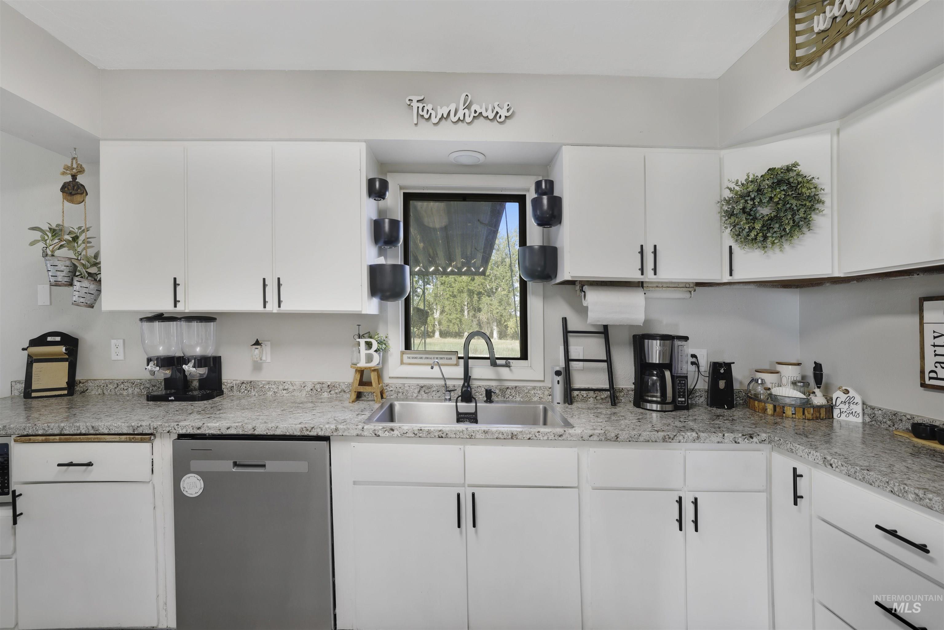 Kitchen featuring dishwasher and white cabinetry