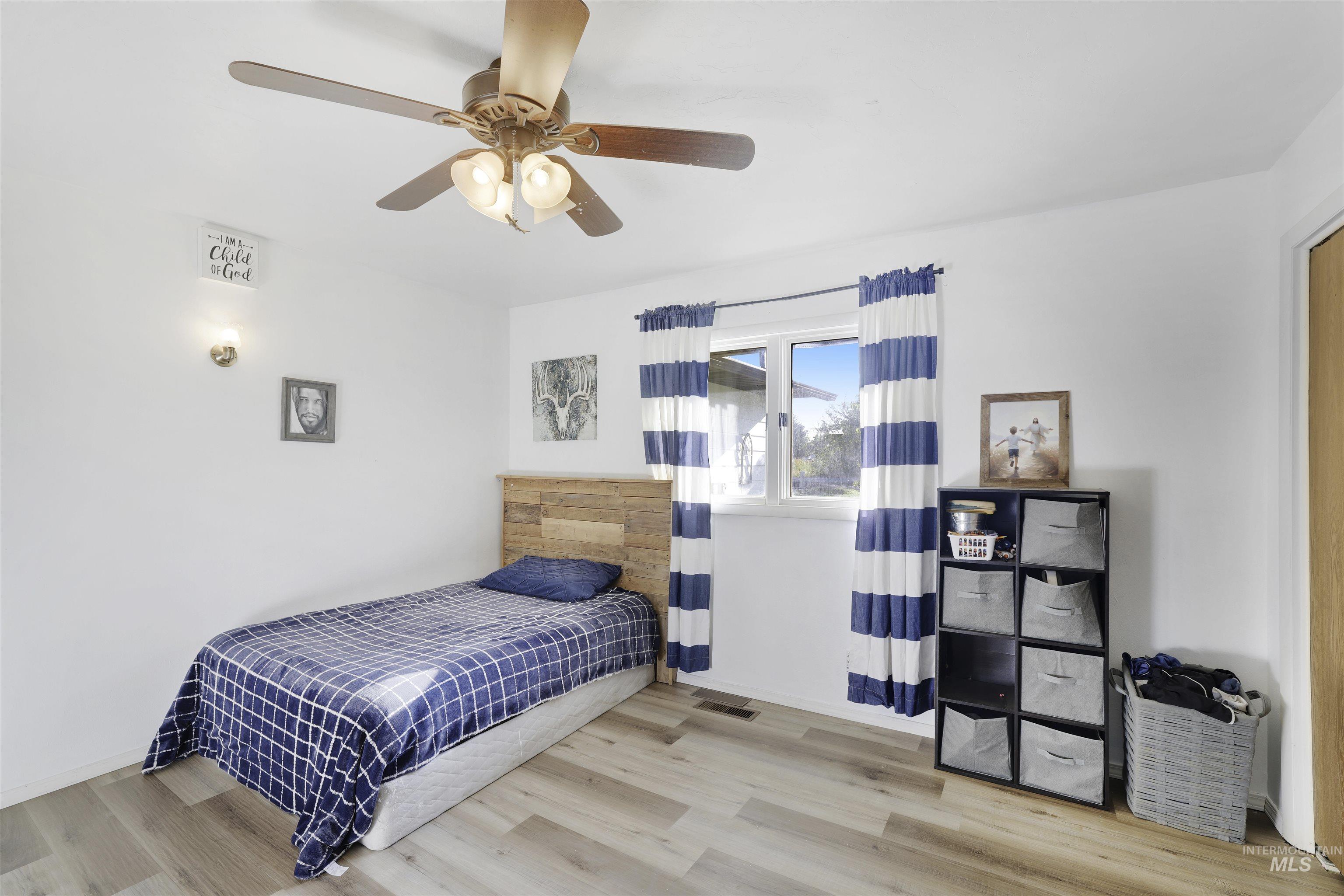 Bedroom featuring wood finished floors and a ceiling fan