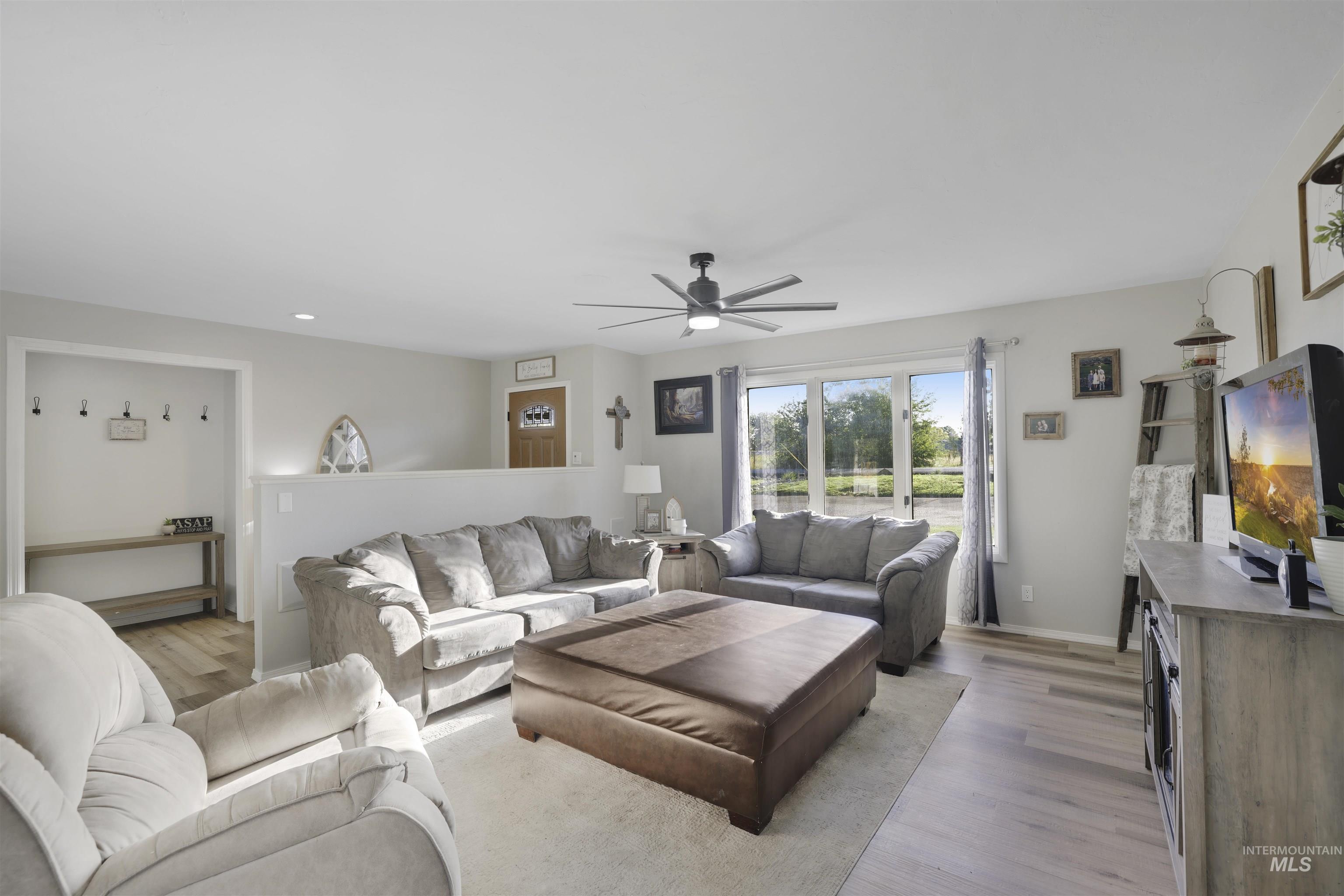 Living area featuring light wood-style floors and a ceiling fan