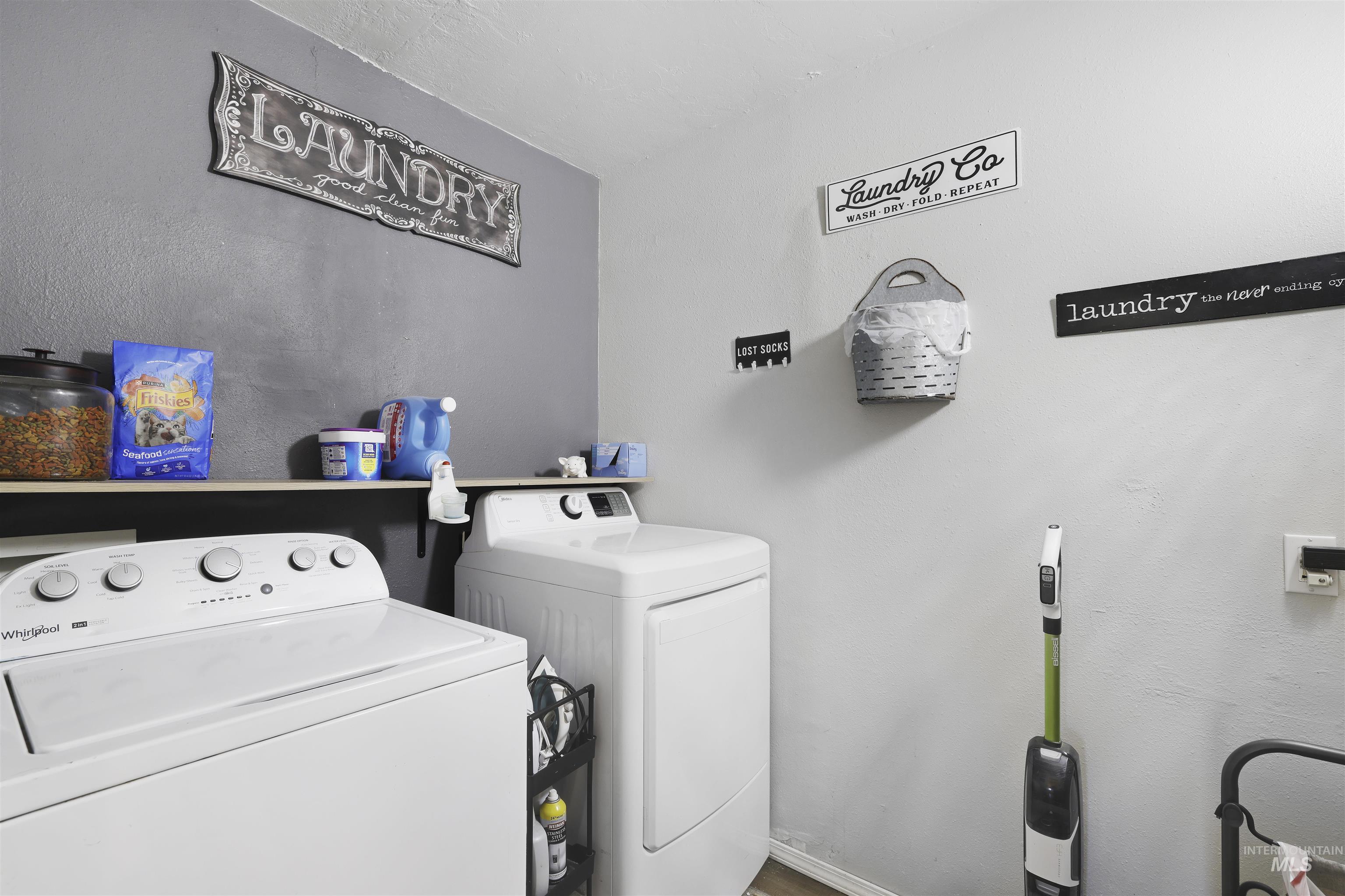 Laundry area featuring a textured wall and independent washer and dryer