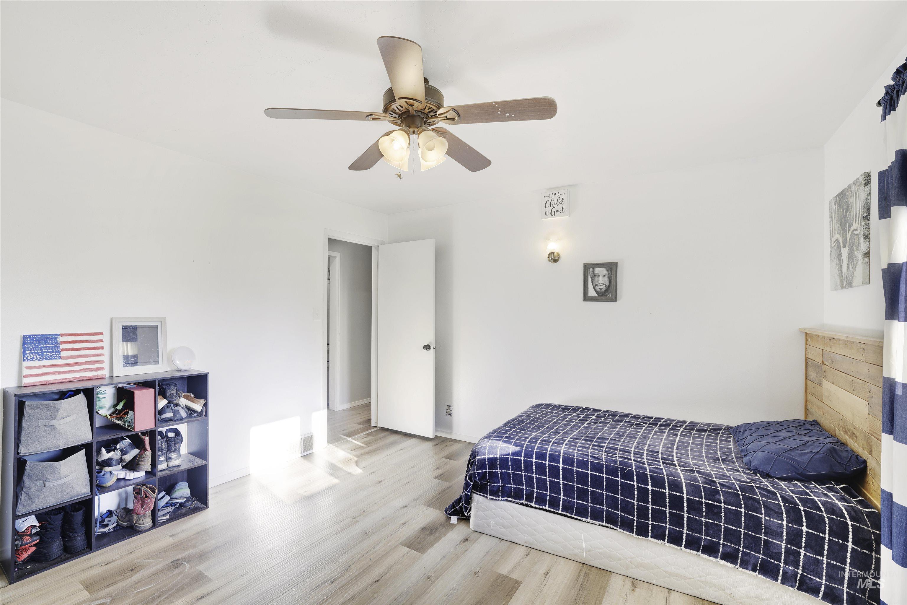 Bedroom with wood finished floors and a ceiling fan
