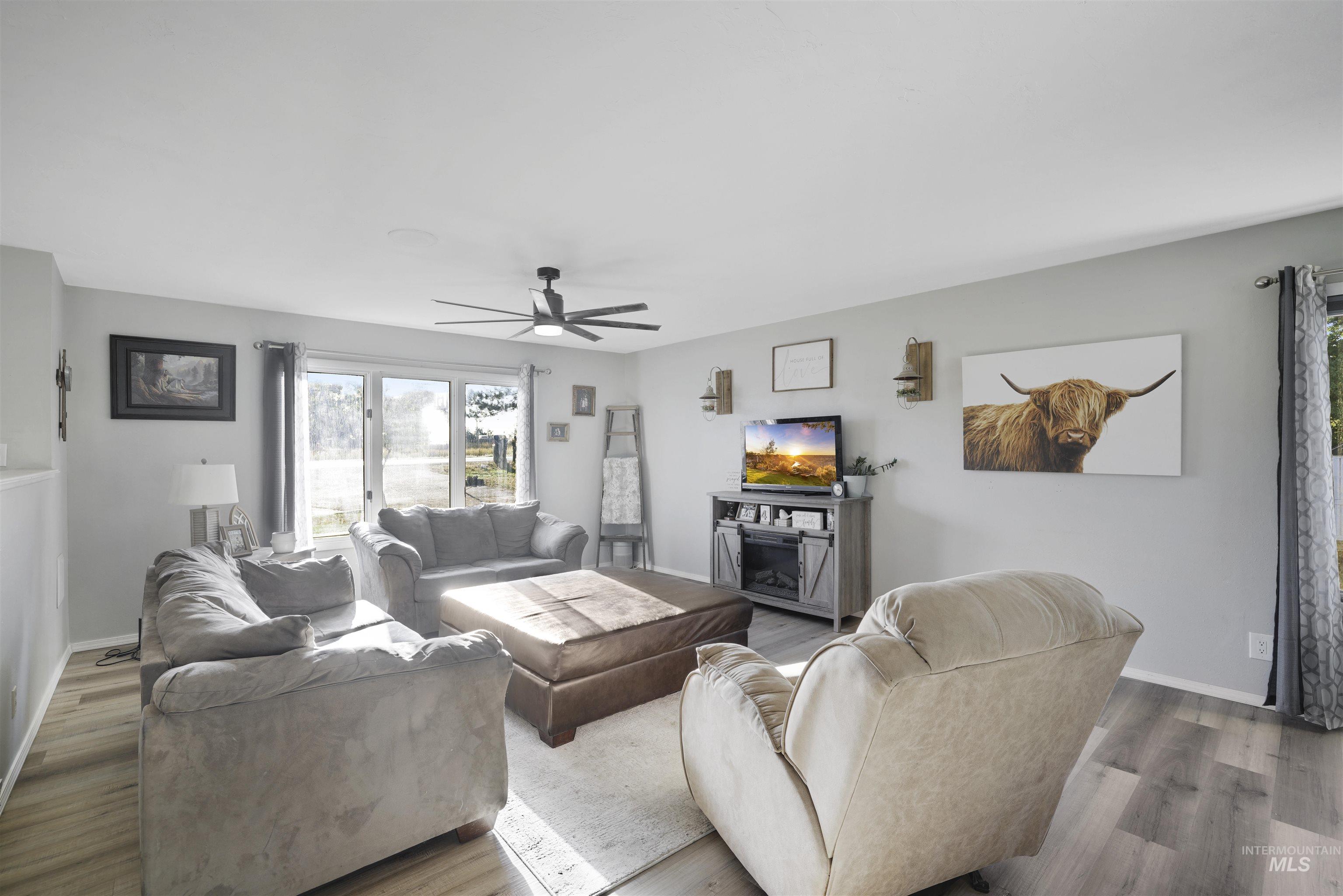 Living area featuring ceiling fan and wood finished floors