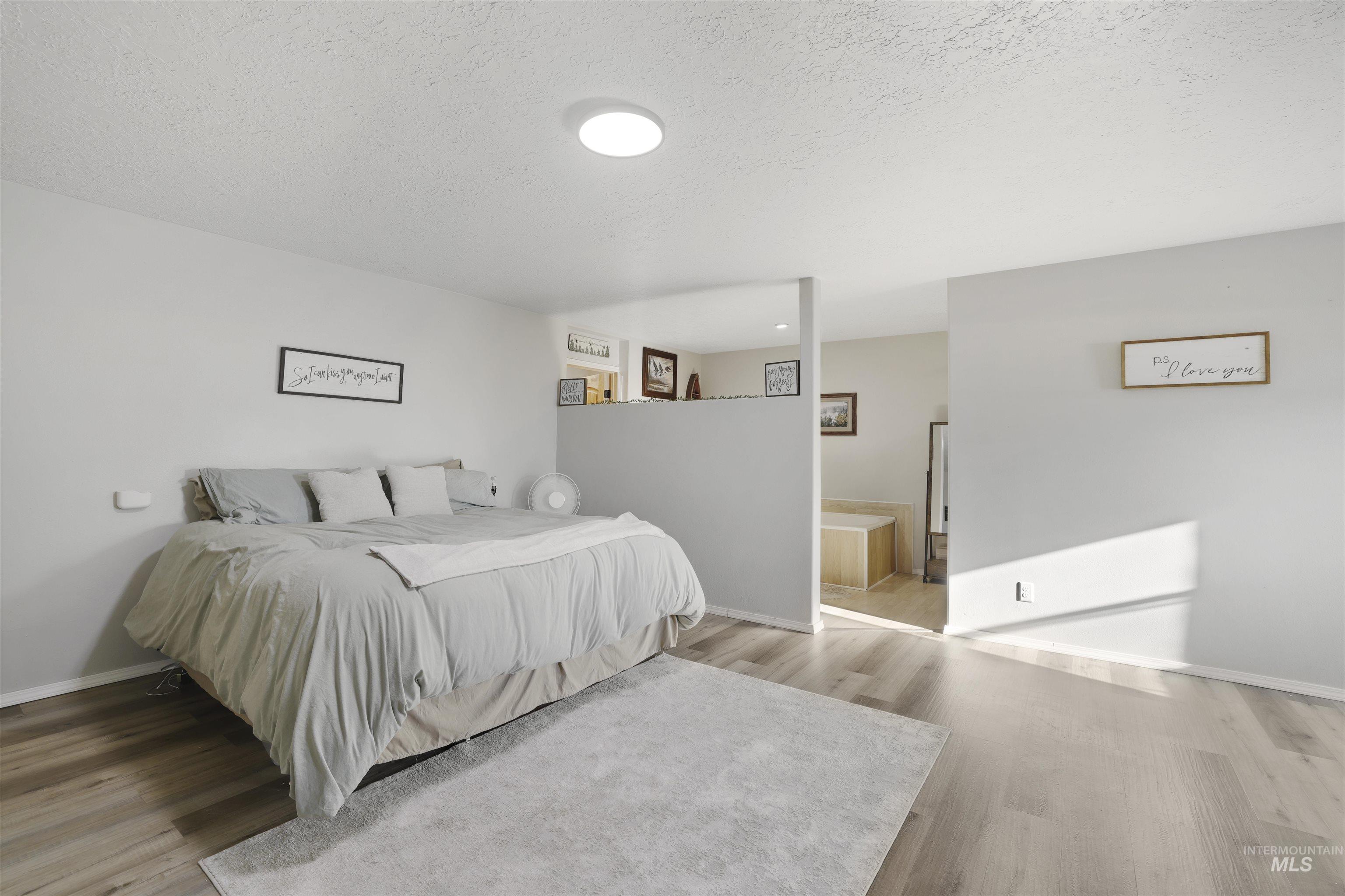 Bedroom featuring a textured ceiling and light wood-type flooring