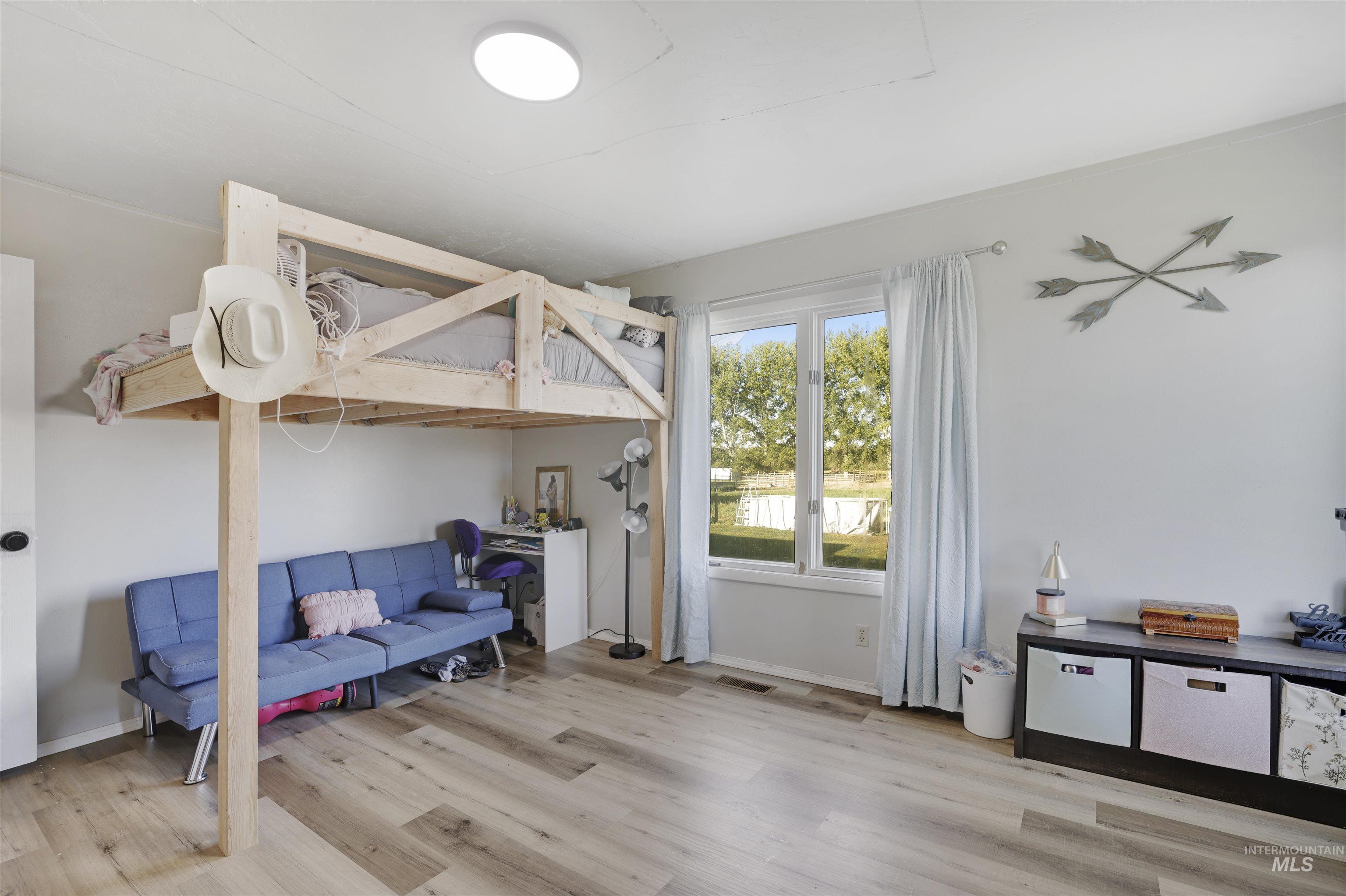 Bedroom with light wood-style flooring and baseboards