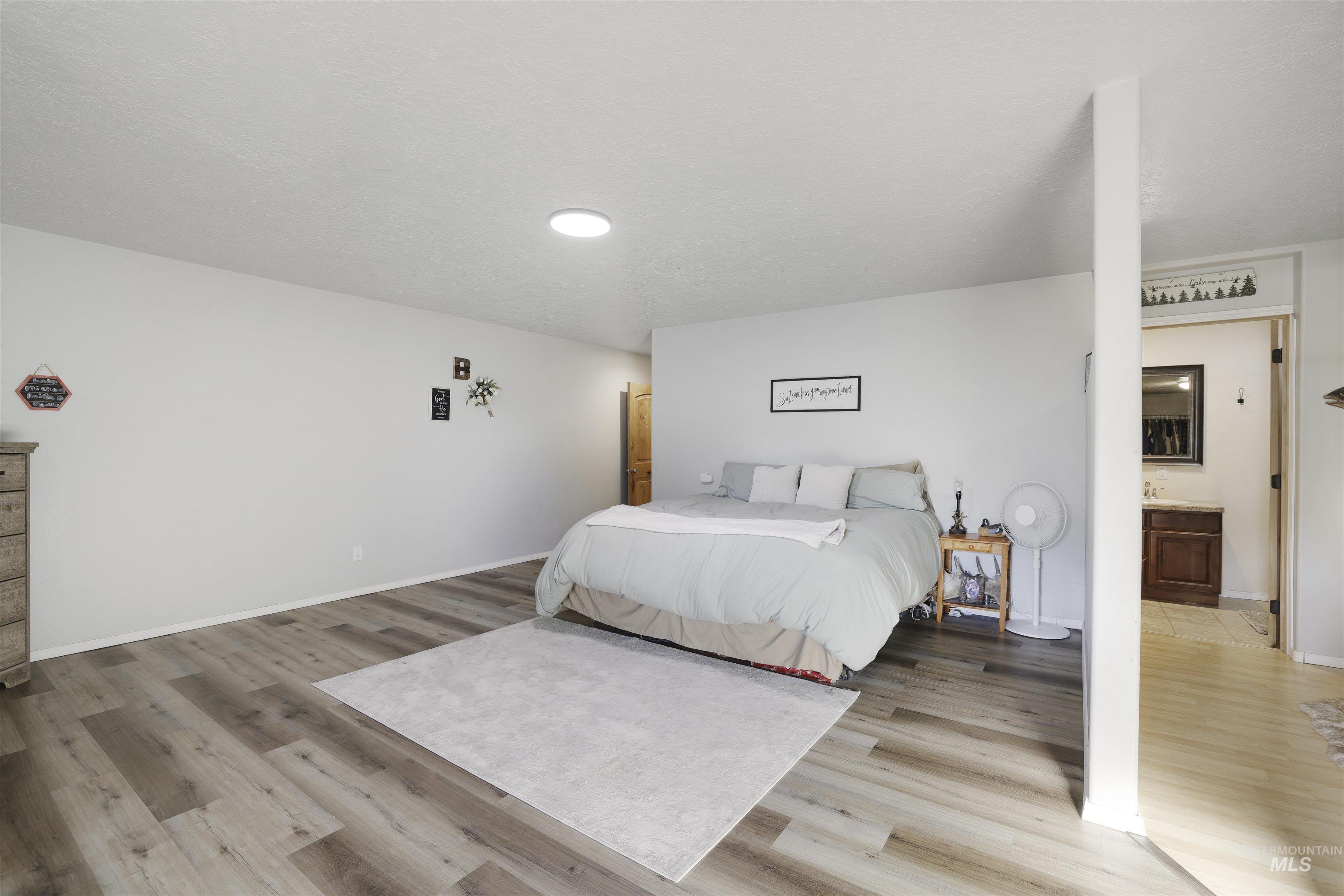 Bedroom featuring light wood-style floors and connected bathroom