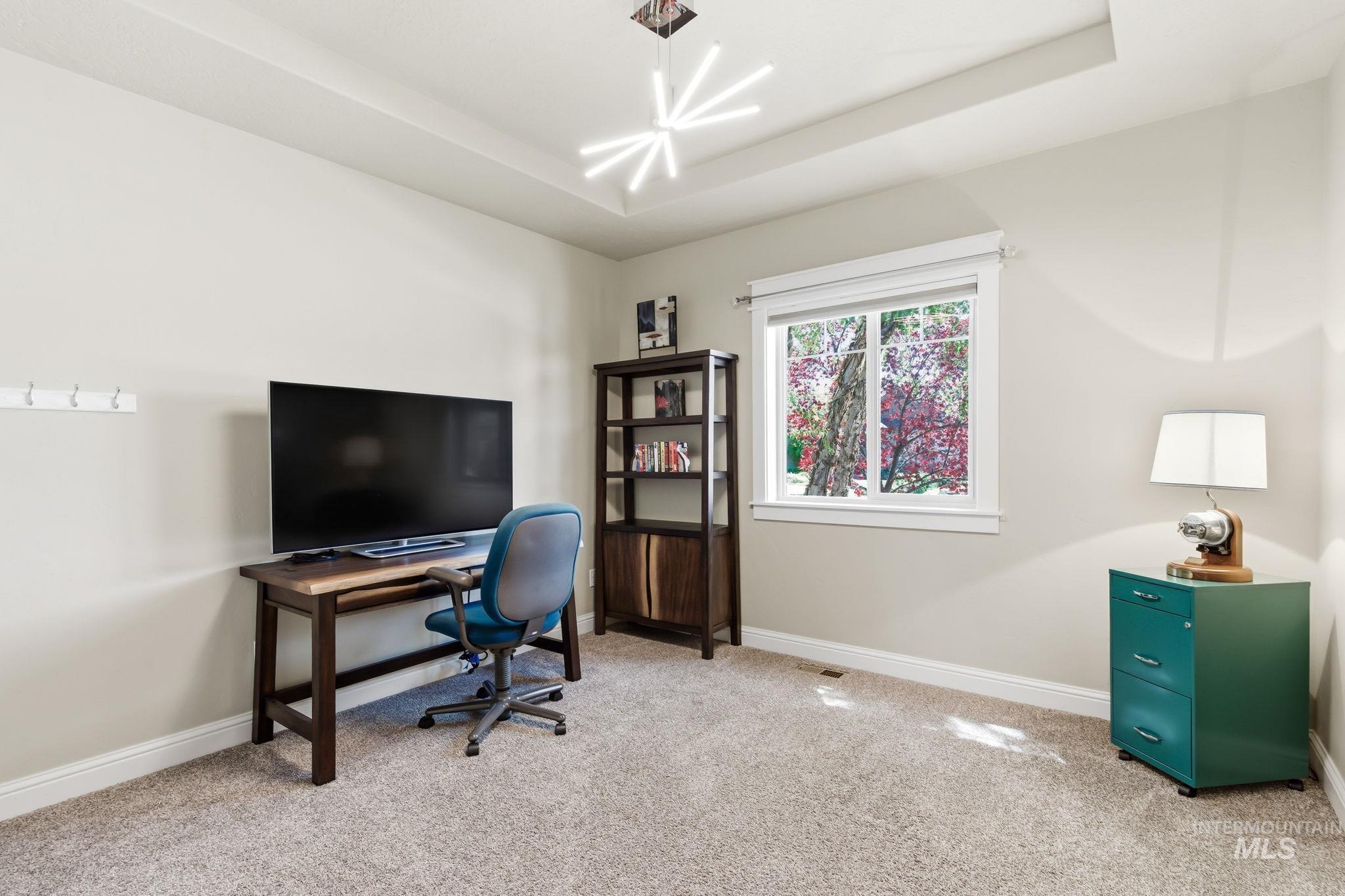 Recessed ceiling with a contemporary starburst light fixture and light-toned carpeting