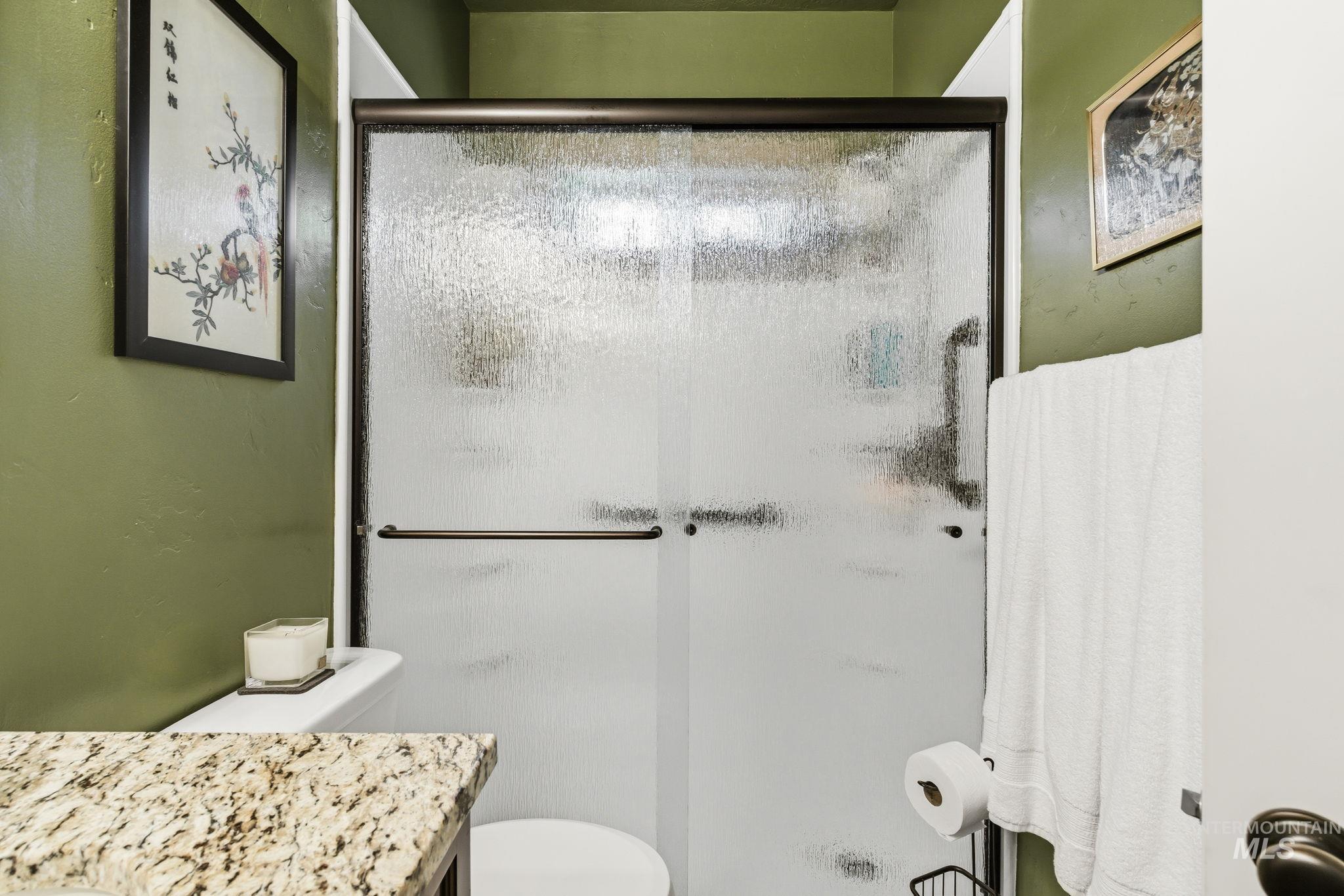 Shower enclosure with a bronze-finish frame and textured privacy glass