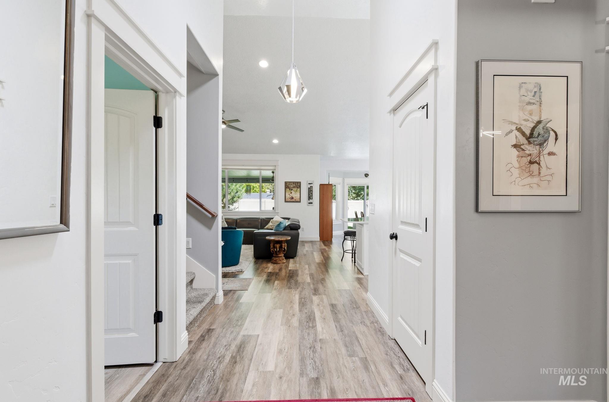 Entryway featuring wood-finish flooring, vaulted ceilings, recessed lighting, and white trim