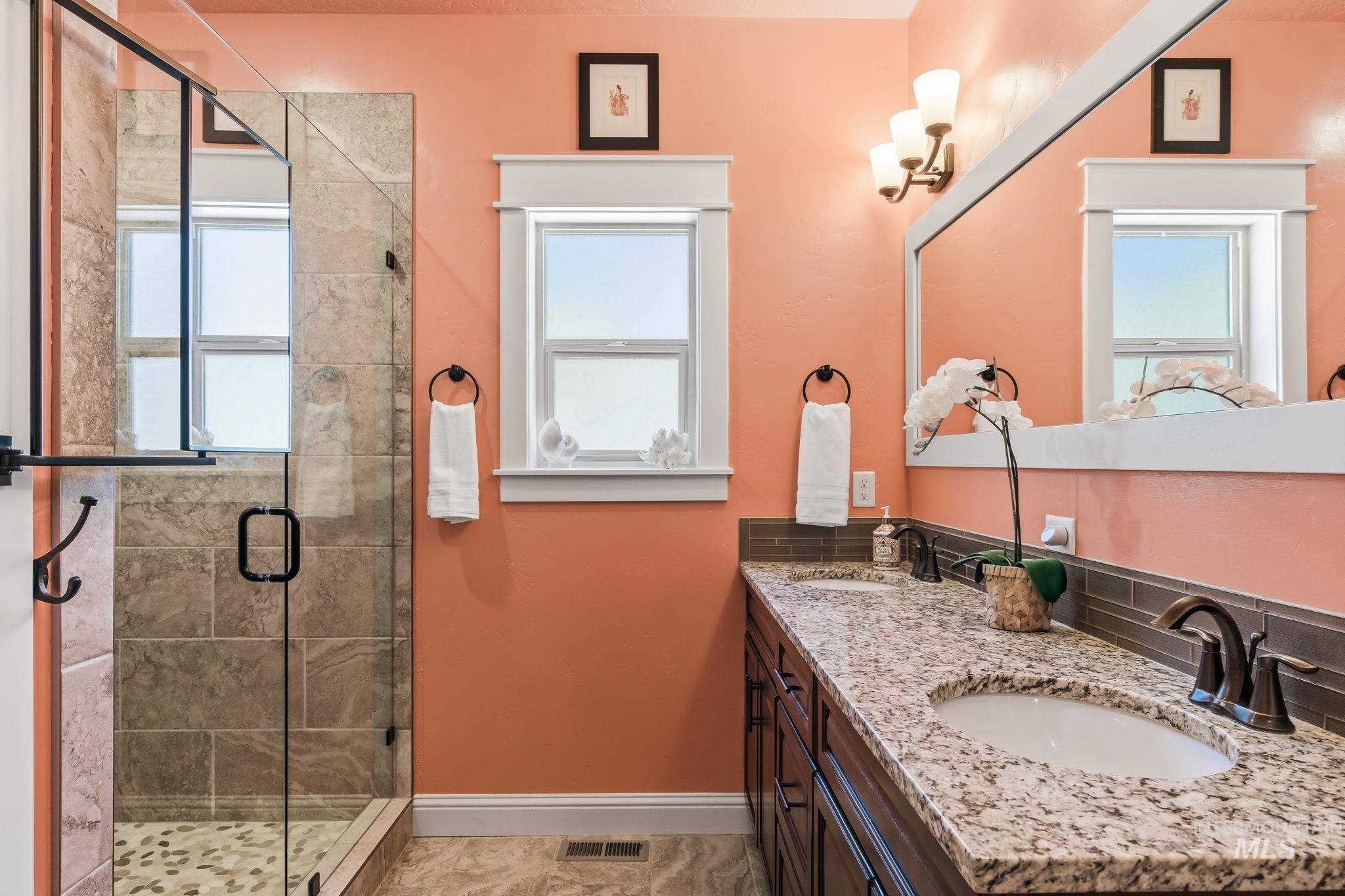Dual vanity with undermount sinks, granite countertops, and dark wood cabinetry