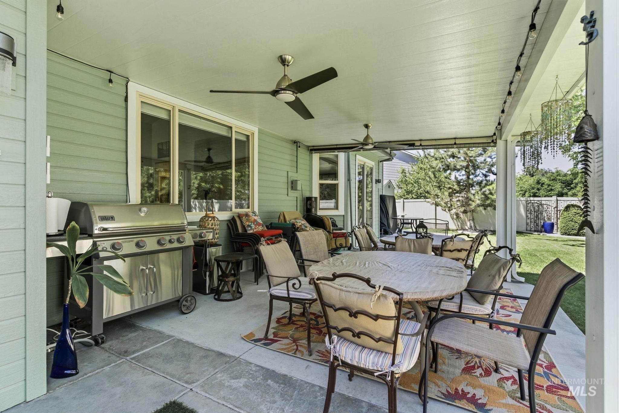 Expansive covered patio featuring concrete flooring, an outdoor ceiling fan, recessed lighting, and a sliding glass door