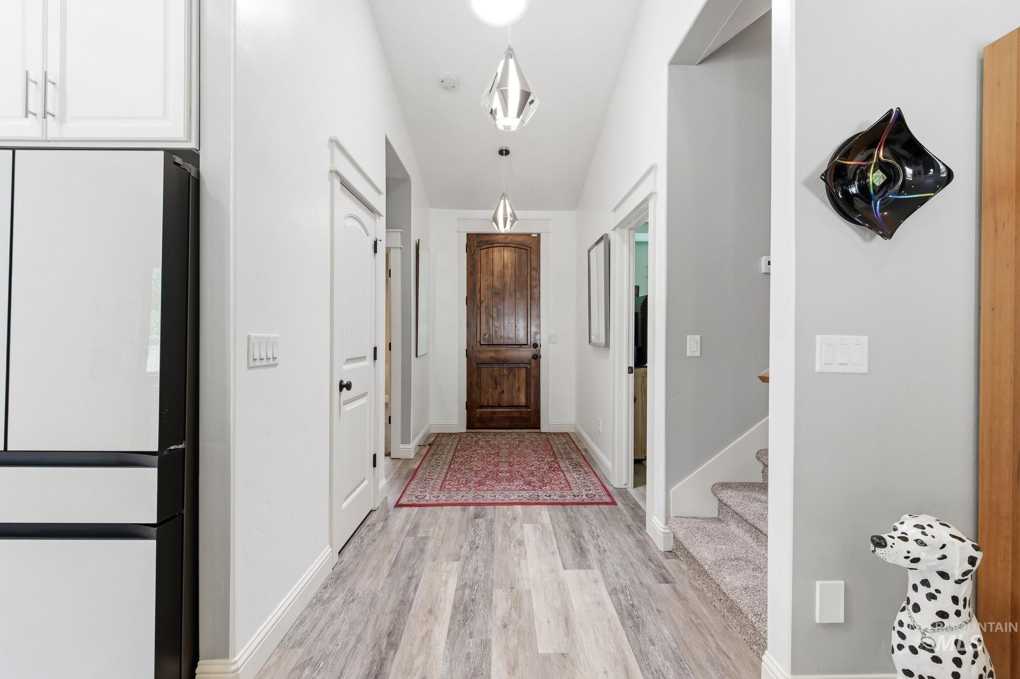 Hallway featuring wood-finish flooring, recessed lighting, and a paneled interior door