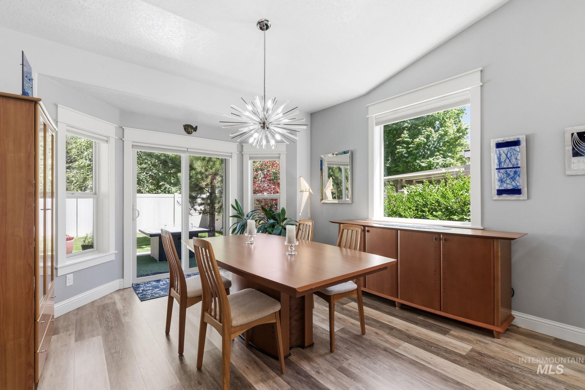 Dining area featuring wood-finish flooring and a vaulted ceiling