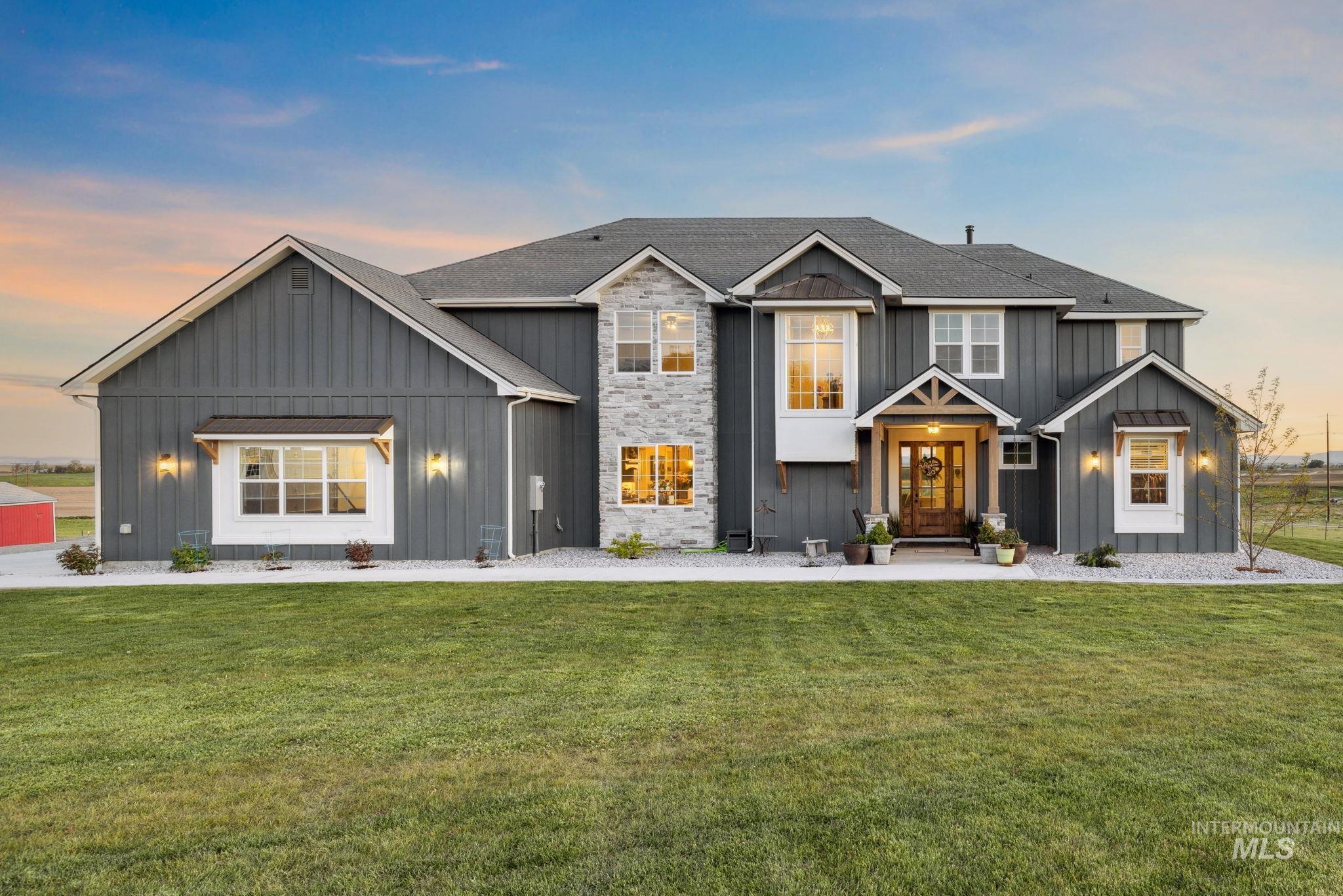 View of front facade with board and batten siding and a front yard