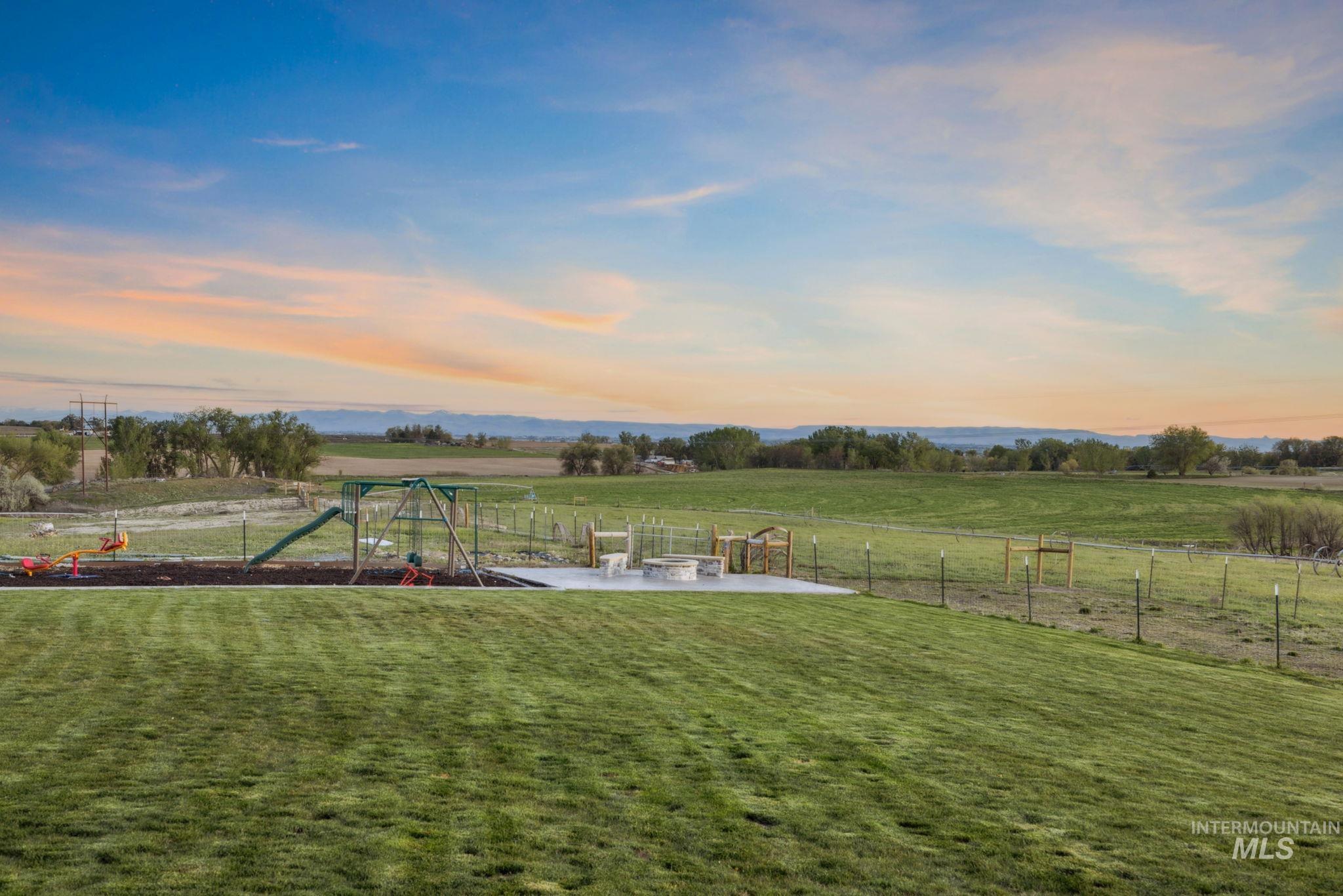 View of yard featuring a view of countryside, a playground, and an outdoor fire pit