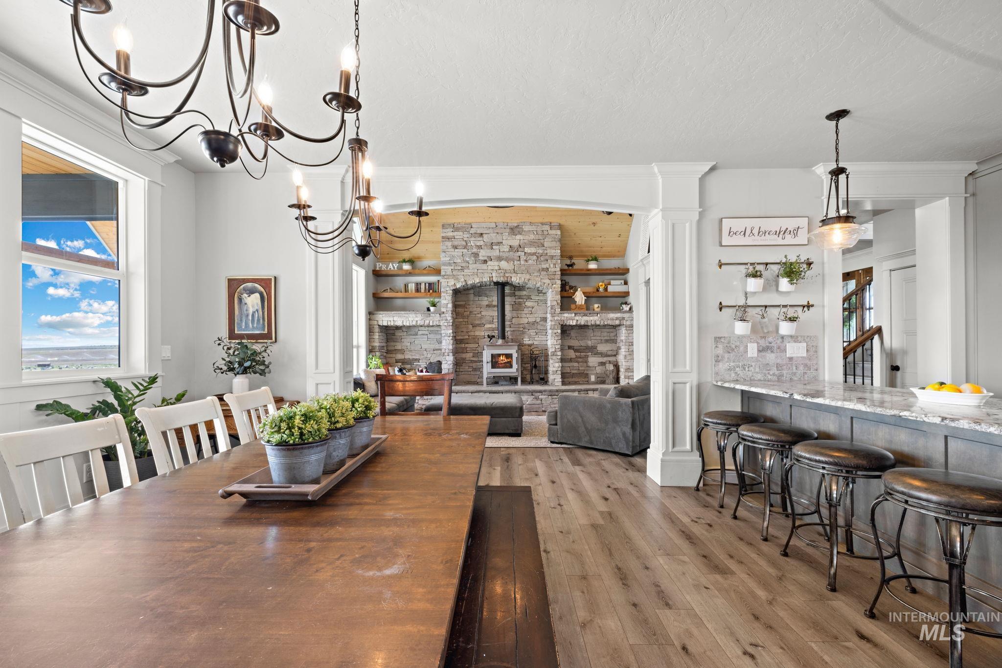 Dining space featuring a wood stove, light wood-type flooring, and plenty of natural light
