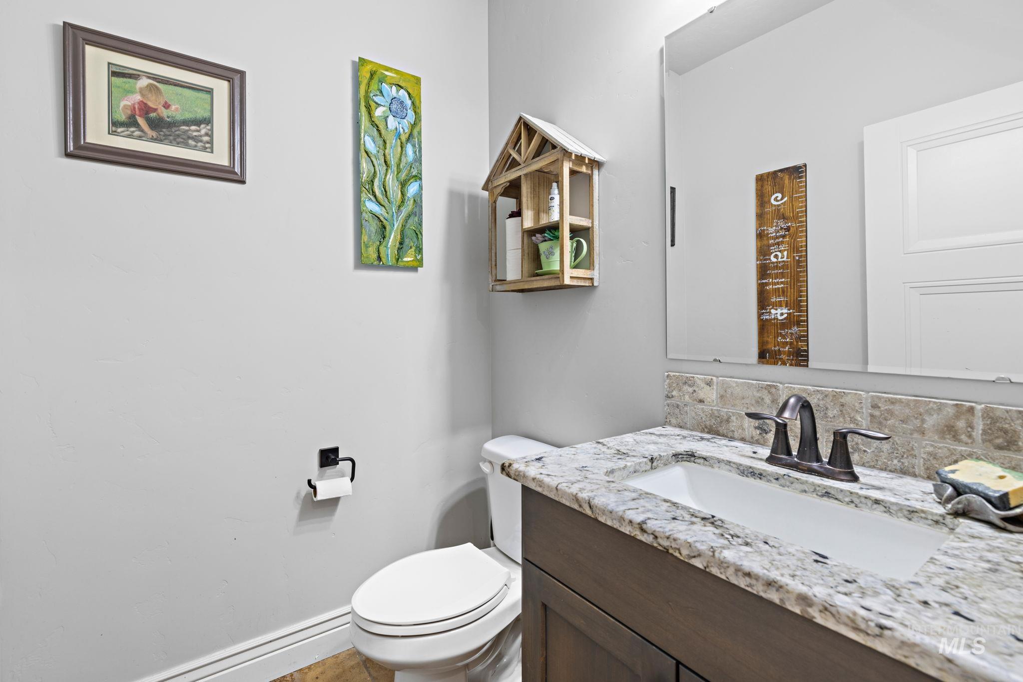 Half bath featuring backsplash and vanity