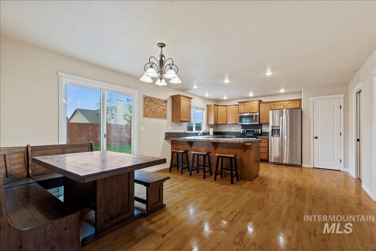 Dining space featuring light wood finished floors, a chandelier, and recessed lighting
