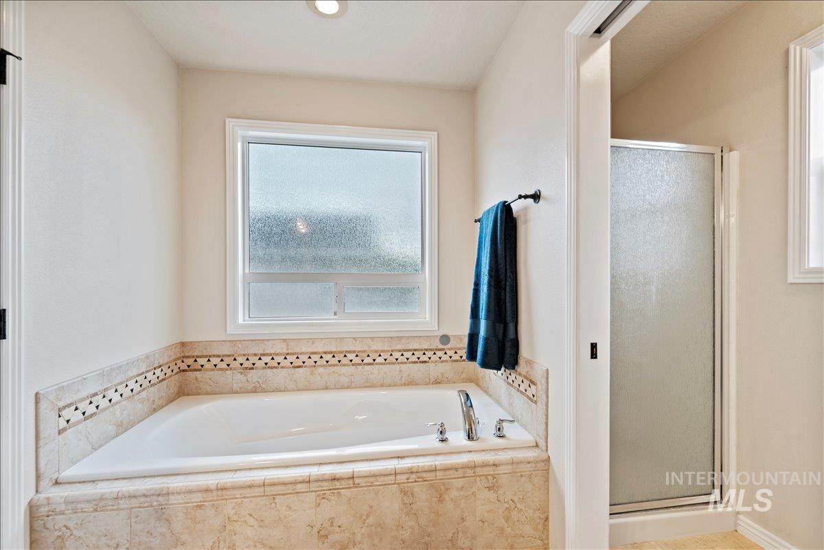 Full bath featuring a stall shower and a garden tub