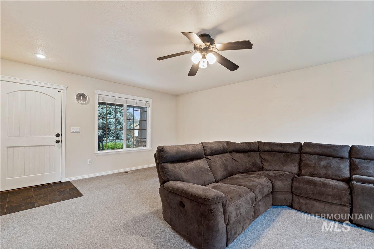 Living area with carpet and a ceiling fan