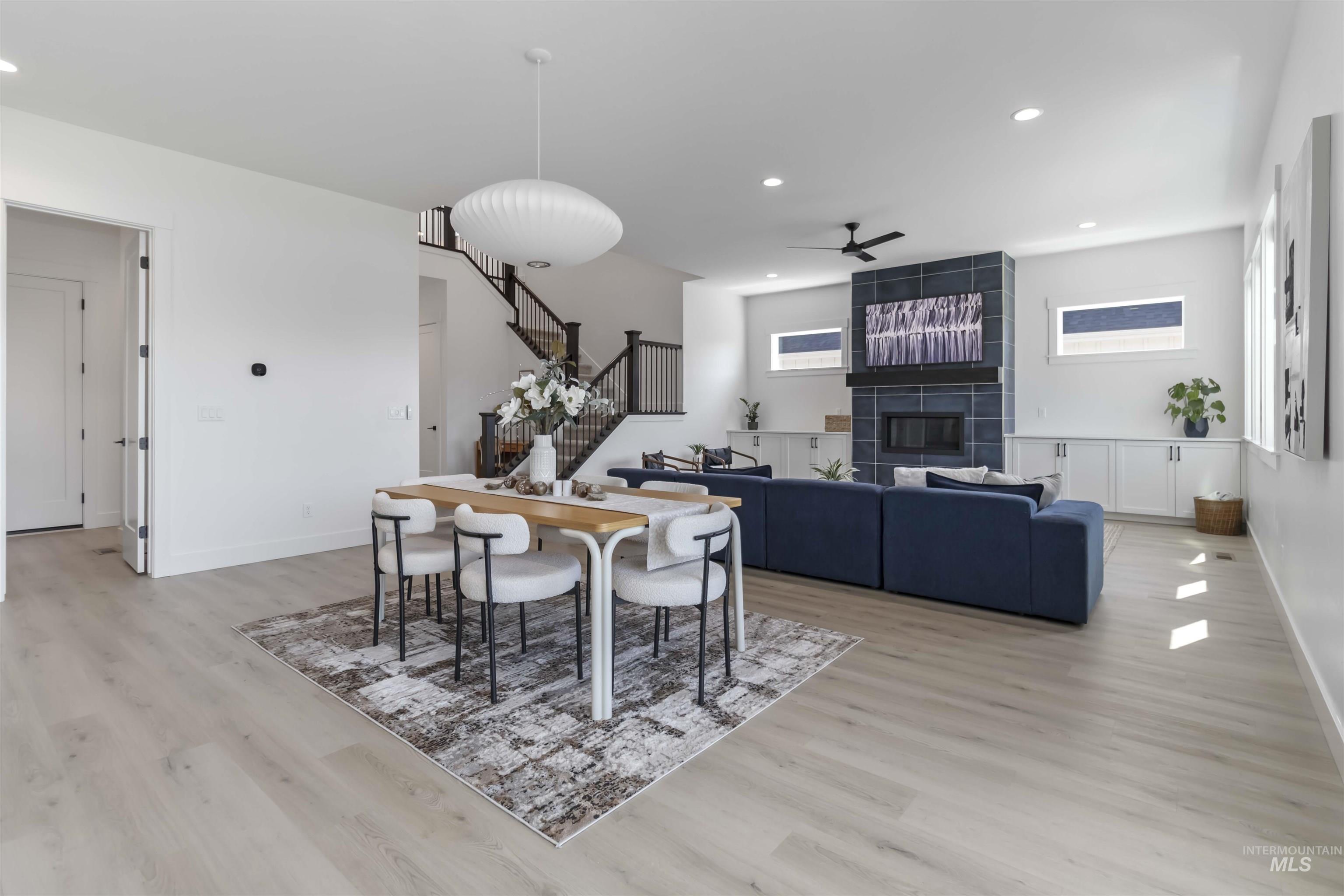 Dining room with a tile fireplace, recessed lighting, light wood-style floors, and ceiling fan