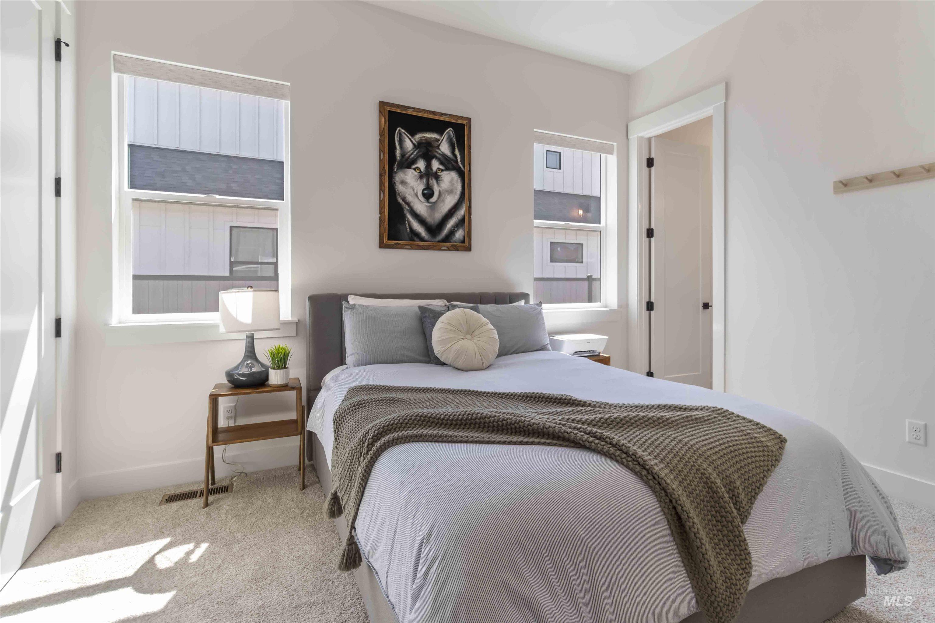 Carpeted bedroom featuring multiple windows