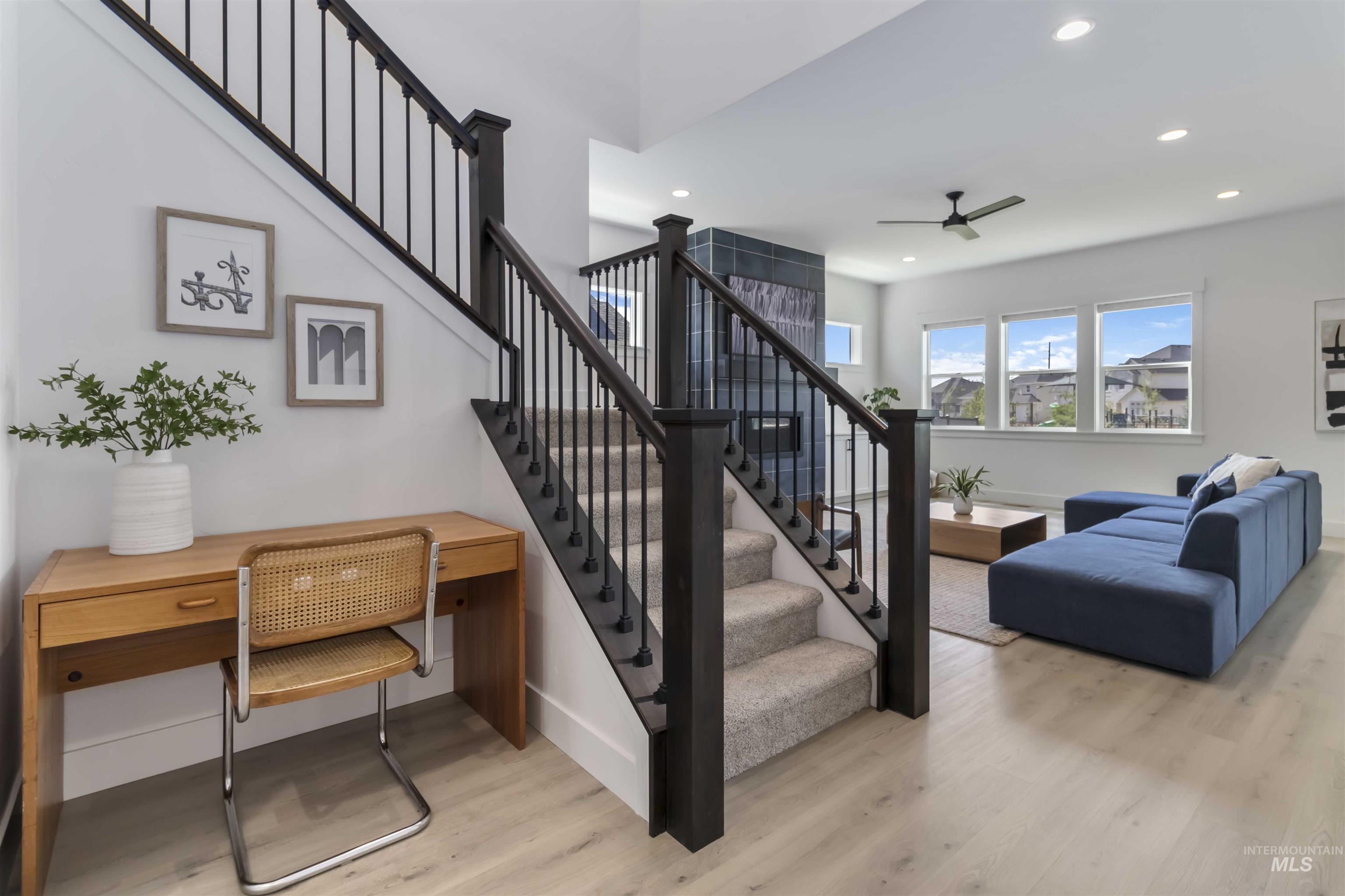 Stairs with wood finished floors, ceiling fan, and recessed lighting
